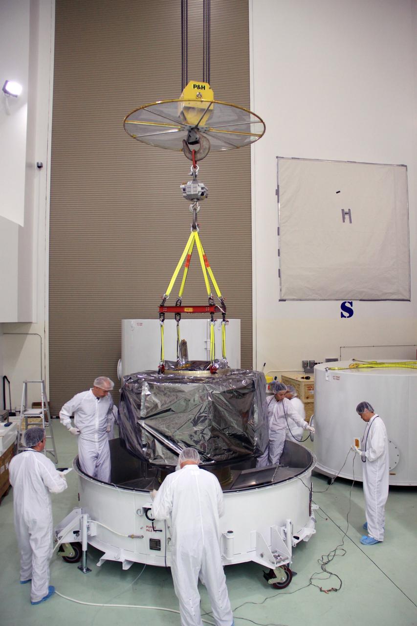 CAPE CANAVERAL, Fla. – In the clean room high bay at the Astrotech payload processing facility near NASA’s Kennedy Space Center in Florida, Applied Physics Laboratory technicians prepare to lift NASA's Radiation Belt Storm Probe B, wrapped in a protective shroud, from the bottom of its shipping container. Prelaunch preparations and spacecraft testing will follow.      The Radiation Belt Storm Probes, or RBSP, mission will help us understand the sun’s influence on Earth and near-Earth space by studying the Earth’s radiation belts on various scales of space and time. RBSP instruments will provide the measurements needed to characterize and quantify the plasma processes that produce very energetic ions and relativistic electrons. The mission is part of NASA’s broader Living With a Star Program that was conceived to explore fundamental processes that operate throughout the solar system, particularly those that generate hazardous space weather effects in the vicinity of Earth and phenomena that could impact solar system exploration. RBSP will begin its mission of exploration of Earth's Van Allen radiation belts and the extremes of space weather after launch. Launch aboard a United Launch Alliance Atlas V rocket is scheduled for August 23. For more information, visit http://www.nasa.gov/rbsp. Photo credit: NASA/Jim Grossmann