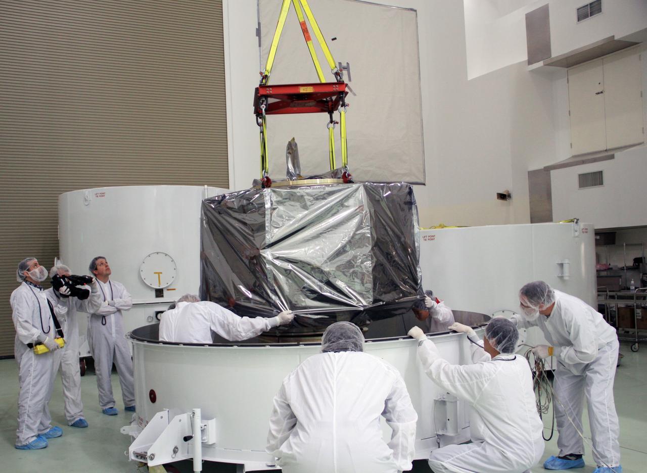 CAPE CANAVERAL, Fla. – In the clean room high bay at the Astrotech payload processing facility near NASA’s Kennedy Space Center in Florida, Applied Physics Laboratory technicians lift NASA's Radiation Belt Storm Probe B, wrapped in a protective shroud, from the bottom of its shipping container. Prelaunch preparations and spacecraft testing will follow.      The Radiation Belt Storm Probes, or RBSP, mission will help us understand the sun’s influence on Earth and near-Earth space by studying the Earth’s radiation belts on various scales of space and time. RBSP instruments will provide the measurements needed to characterize and quantify the plasma processes that produce very energetic ions and relativistic electrons. The mission is part of NASA’s broader Living With a Star Program that was conceived to explore fundamental processes that operate throughout the solar system, particularly those that generate hazardous space weather effects in the vicinity of Earth and phenomena that could impact solar system exploration. RBSP will begin its mission of exploration of Earth's Van Allen radiation belts and the extremes of space weather after launch. Launch aboard a United Launch Alliance Atlas V rocket is scheduled for August 23. For more information, visit http://www.nasa.gov/rbsp. Photo credit: NASA/Jim Grossmann