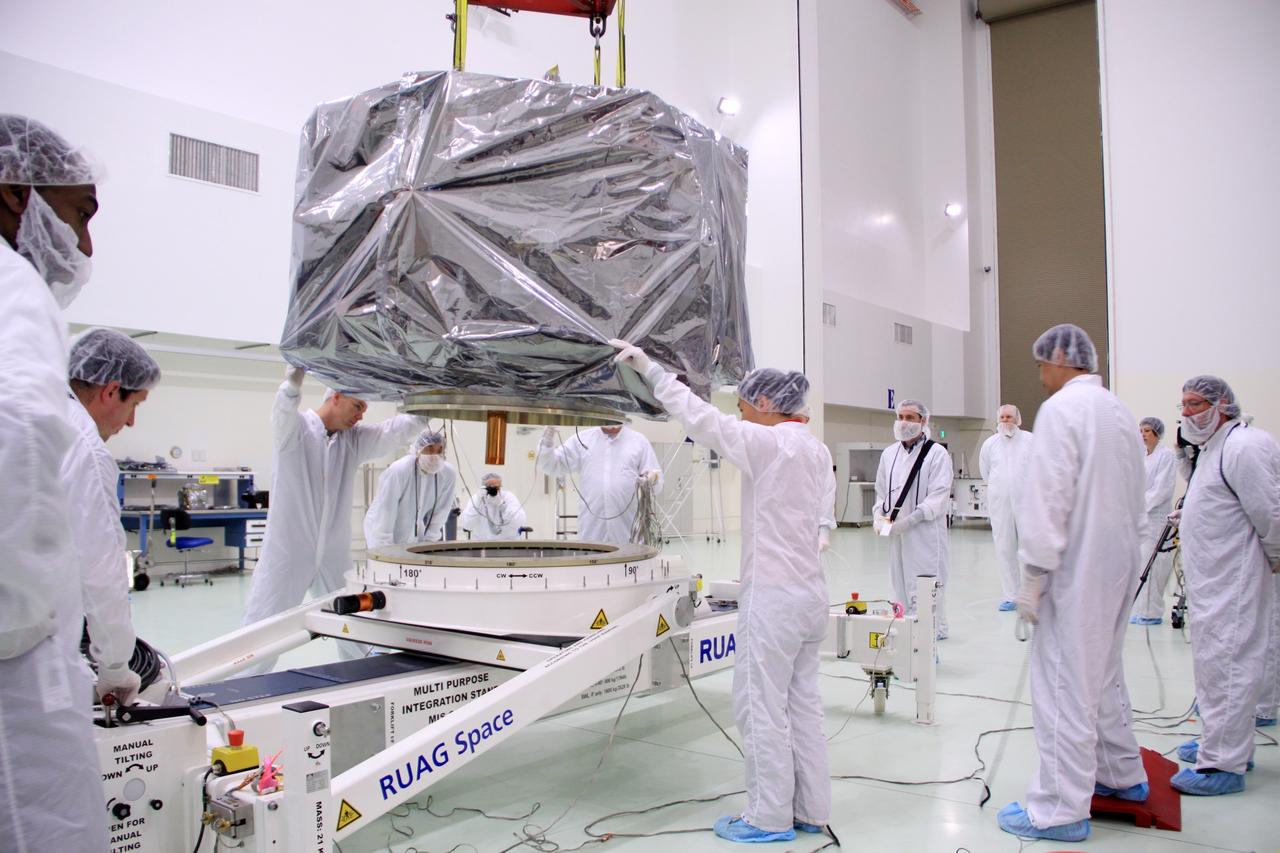 CAPE CANAVERAL, Fla. – In the clean room high bay at the Astrotech payload processing facility near NASA’s Kennedy Space Center in Florida, Applied Physics Laboratory technicians lower NASA's Radiation Belt Storm Probe B, wrapped in a protective shroud, onto a test stand. Prelaunch preparations and spacecraft testing will follow.      The Radiation Belt Storm Probes, or RBSP, mission will help us understand the sun’s influence on Earth and near-Earth space by studying the Earth’s radiation belts on various scales of space and time. RBSP instruments will provide the measurements needed to characterize and quantify the plasma processes that produce very energetic ions and relativistic electrons. The mission is part of NASA’s broader Living With a Star Program that was conceived to explore fundamental processes that operate throughout the solar system, particularly those that generate hazardous space weather effects in the vicinity of Earth and phenomena that could impact solar system exploration. RBSP will begin its mission of exploration of Earth's Van Allen radiation belts and the extremes of space weather after launch. Launch aboard a United Launch Alliance Atlas V rocket is scheduled for August 23. For more information, visit http://www.nasa.gov/rbsp. Photo credit: NASA/Jim Grossmann