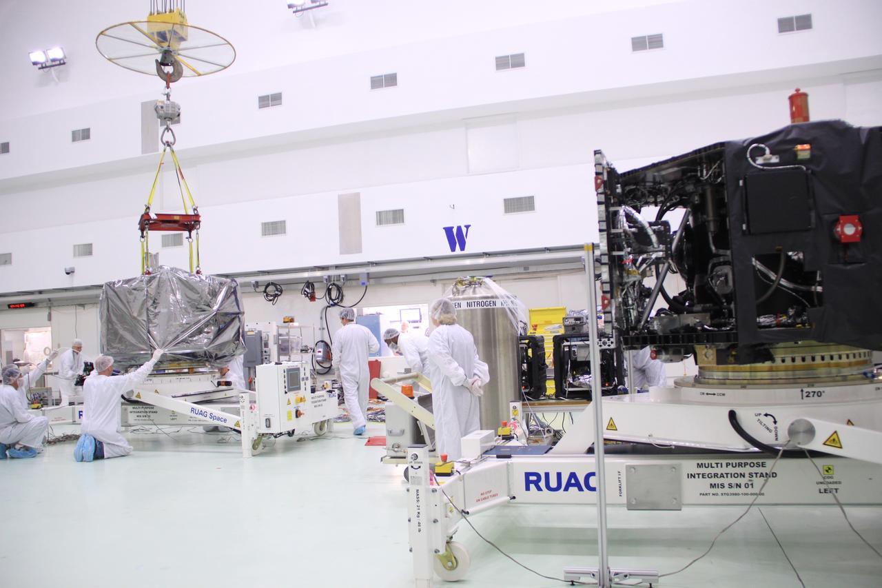 CAPE CANAVERAL, Fla. – In the clean room high bay at the Astrotech payload processing facility near NASA’s Kennedy Space Center in Florida, Applied Physics Laboratory technicians position NASA's Radiation Belt Storm Probe B, wrapped in a protective shroud, on a test stand. Prelaunch preparations and spacecraft testing will follow.      The Radiation Belt Storm Probes, or RBSP, mission will help us understand the sun’s influence on Earth and near-Earth space by studying the Earth’s radiation belts on various scales of space and time. RBSP instruments will provide the measurements needed to characterize and quantify the plasma processes that produce very energetic ions and relativistic electrons. The mission is part of NASA’s broader Living With a Star Program that was conceived to explore fundamental processes that operate throughout the solar system, particularly those that generate hazardous space weather effects in the vicinity of Earth and phenomena that could impact solar system exploration. RBSP will begin its mission of exploration of Earth's Van Allen radiation belts and the extremes of space weather after launch. Launch aboard a United Launch Alliance Atlas V rocket is scheduled for August 23. For more information, visit http://www.nasa.gov/rbsp. Photo credit: NASA/Jim Grossmann