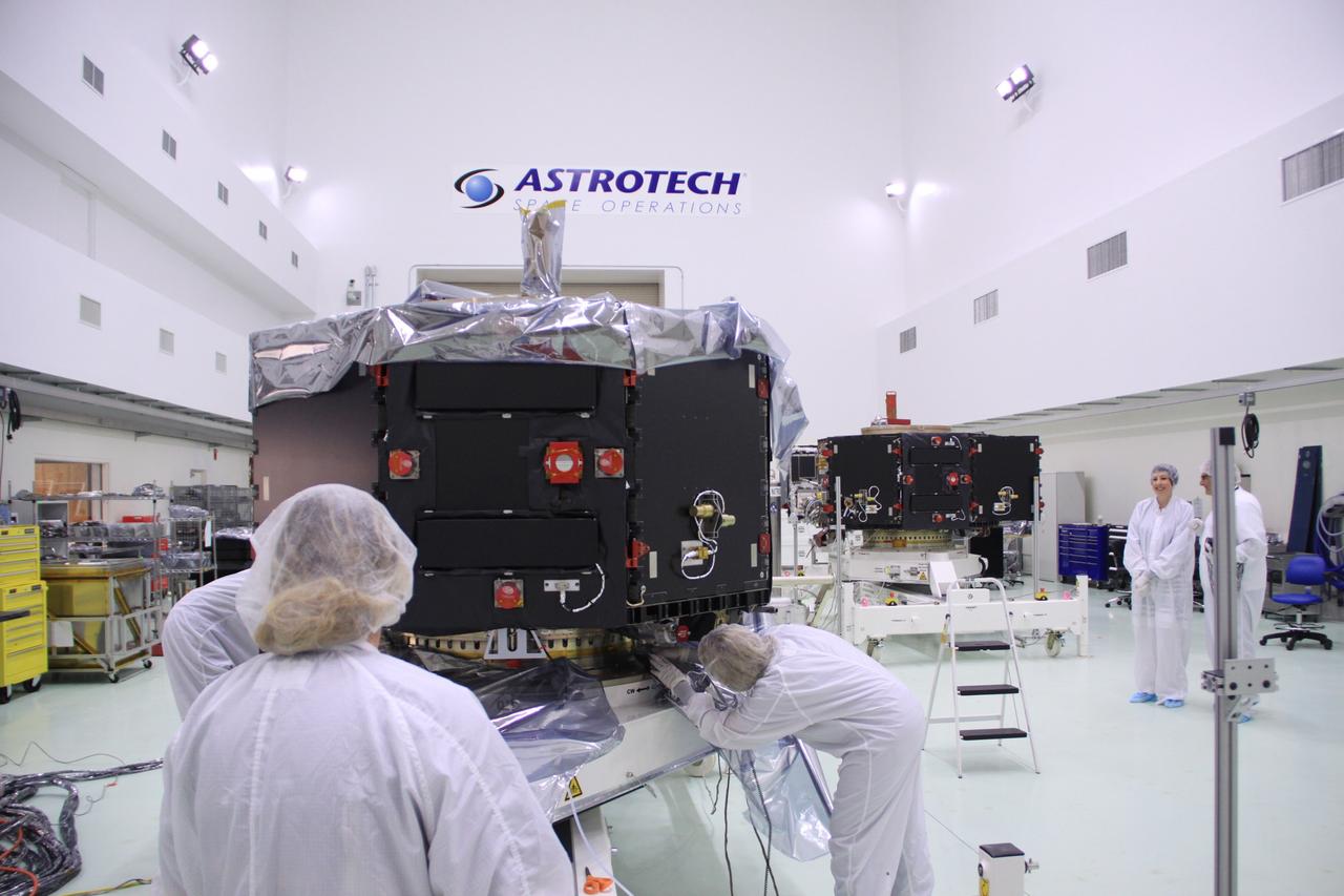 CAPE CANAVERAL, Fla. – In the clean room high bay at the Astrotech payload processing facility near NASA’s Kennedy Space Center in Florida, Applied Physics Laboratory technicians remove the protective shroud from around NASA's Radiation Belt Storm Probe B.  Its twin, Radiation Belt Storm Probe A, in the background, has already been uncovered.      The Radiation Belt Storm Probes, or RBSP, mission will help us understand the sun’s influence on Earth and near-Earth space by studying the Earth’s radiation belts on various scales of space and time. RBSP instruments will provide the measurements needed to characterize and quantify the plasma processes that produce very energetic ions and relativistic electrons. The mission is part of NASA’s broader Living With a Star Program that was conceived to explore fundamental processes that operate throughout the solar system, particularly those that generate hazardous space weather effects in the vicinity of Earth and phenomena that could impact solar system exploration. RBSP will begin its mission of exploration of Earth's Van Allen radiation belts and the extremes of space weather after launch. Launch aboard a United Launch Alliance Atlas V rocket is scheduled for August 23. For more information, visit http://www.nasa.gov/rbsp. Photo credit: NASA/Jim Grossmann