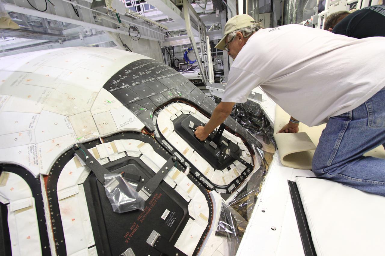 CAPE CANAVERAL, Fla. – Inside Orbiter Processing Facility-1 at NASA’s Kennedy Space Center in Florida, United Space Alliance technicians install window No. 4 on space shuttle Atlantis.    The work is part of the Space Shuttle Program’s transition and retirement processing of space shuttles Atlantis and Endeavour. Atlantis is being prepared for display at the Kennedy Space Center Visitor Complex and is scheduled to roll over to the complex in November. The visitor complex is targeting a July 2013 grand opening for Atlantis’ new home. Photo credit: NASA/Jim Grossmann