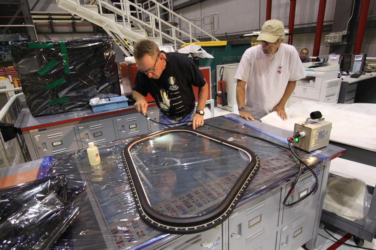 CAPE CANAVERAL, Fla. – Inside Orbiter Processing Facility-1 at NASA’s Kennedy Space Center in Florida, United Space Alliance technicians inspect window No. 4 in order to prepare it for installation on space shuttle Atlantis.    The work is part of the Space Shuttle Program’s transition and retirement processing of space shuttles Atlantis and Endeavour. Atlantis is being prepared for display at the Kennedy Space Center Visitor Complex and is scheduled to roll over to the complex in November. The visitor complex is targeting a July 2013 grand opening for Atlantis’ new home. Photo credit: NASA/Jim Grossmann