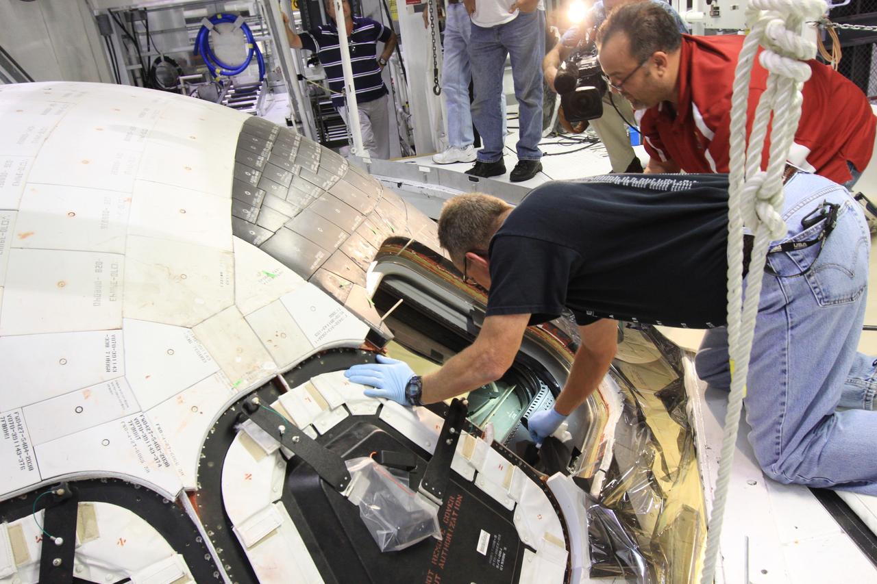 CAPE CANAVERAL, Fla. – Inside Orbiter Processing Facility-1 at NASA’s Kennedy Space Center in Florida, United Space Alliance technicians prepare to install window No. 4 on space shuttle Atlantis.     The work is part of the Space Shuttle Program’s transition and retirement processing of space shuttles Atlantis and Endeavour. Atlantis is being prepared for display at the Kennedy Space Center Visitor Complex and is scheduled to roll over to the complex in November. The visitor complex is targeting a July 2013 grand opening for Atlantis’ new home. Photo credit: NASA/Jim Grossmann