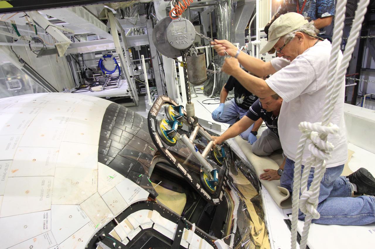 CAPE CANAVERAL, Fla. – Inside Orbiter Processing Facility-1 at NASA’s Kennedy Space Center in Florida, United Space Alliance technicians prepare to install window No. 4 on space shuttle Atlantis.     The work is part of the Space Shuttle Program’s transition and retirement processing of space shuttles Atlantis and Endeavour. Atlantis is being prepared for display at the Kennedy Space Center Visitor Complex and is scheduled to roll over to the complex in November. The visitor complex is targeting a July 2013 grand opening for Atlantis’ new home. Photo credit: NASA/Jim Grossmann