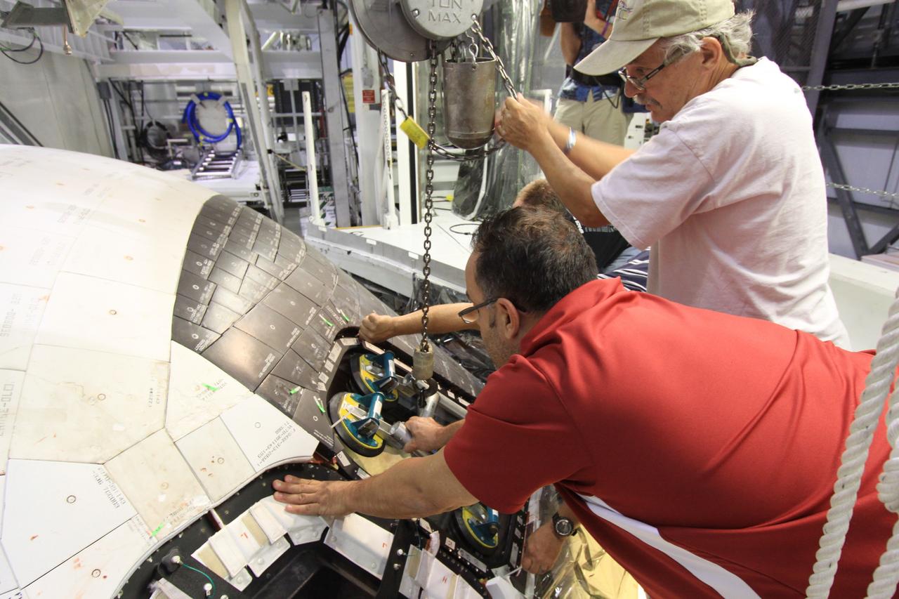 CAPE CANAVERAL, Fla. –Inside Orbiter Processing Facility-1 at NASA’s Kennedy Space Center in Florida, United Space Alliance technicians install one of the components of window No. 4 on space shuttle Atlantis.     The work is part of the Space Shuttle Program’s transition and retirement processing of space shuttles Atlantis and Endeavour. Atlantis is being prepared for display at the Kennedy Space Center Visitor Complex and is scheduled to roll over to the complex in November. The visitor complex is targeting a July 2013 grand opening for Atlantis’ new home. Photo credit: NASA/Jim Grossmann