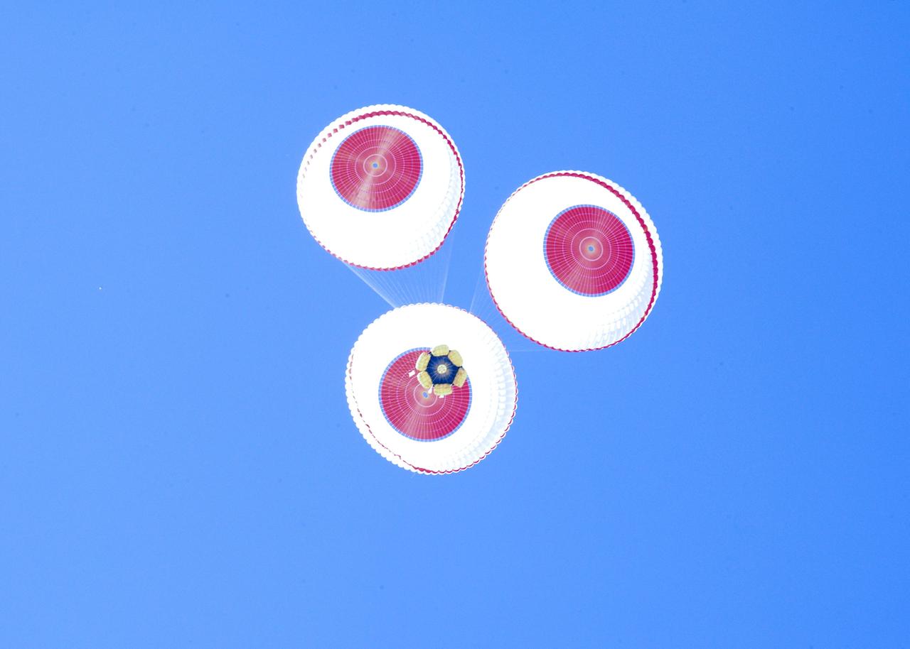DELAMAR DRY LAKE BED, Nev. – The Boeing Company's CST-100 crew capsule floats to a smooth landing beneath three main parachutes over the Delamar Dry Lake Bed near Alamo, Nev. This is the second parachute test that Boeing performed under its partnership with NASA's Commercial Crew Program CCP. The first showed the parachute system’s deployment scheme worked and that it could be re-packed and re-used for this second test.        In 2011, NASA selected Boeing during Commercial Crew Development Round 2 CCDev2) activities to mature the design and development of a crew transportation system with the overall goal of accelerating a United States-led capability to the International Space Station. The goal of CCP is to drive down the cost of space travel as well as open up space to more people than ever before by balancing industry’s own innovative capabilities with NASA's 50 years of human spaceflight experience. Six other aerospace companies also are maturing launch vehicle and spacecraft designs under CCDev2, including Alliant Techsystems Inc. ATK, Excalibur Almaz Inc., Blue Origin, Sierra Nevada, Space Exploration Technologies SpaceX, and United Launch Alliance ULA. For more information, visit www.nasa.gov/commercialcrew. Image credit: Boeing