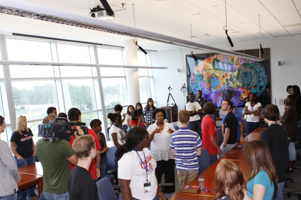 CAPE CANAVERAL, Fla. – Dr. LaNetra C. Tate, center, materials engineer at Kennedy Space Center, is surrounded by students as she welcomes them for their tour of the Space Life Sciences Lab facilities.                  The 26 honor students in chemistry and biology and their teachers got a chance to visit a number of high-tech labs at Kennedy as part of an effort to encourage students in the areas of science, technology, engineering and math. The tenth and eleventh grade students from Terry Parker High School in Jacksonville, Fla., visited a number of vastly different labs during their one-day tour. The group's visit to Kennedy was hosted by the Education Office as part of a nationwide effort by the National Lab Network to help introduce the nation's students to science careers. Photo credit: NASA/Jim Grossmann