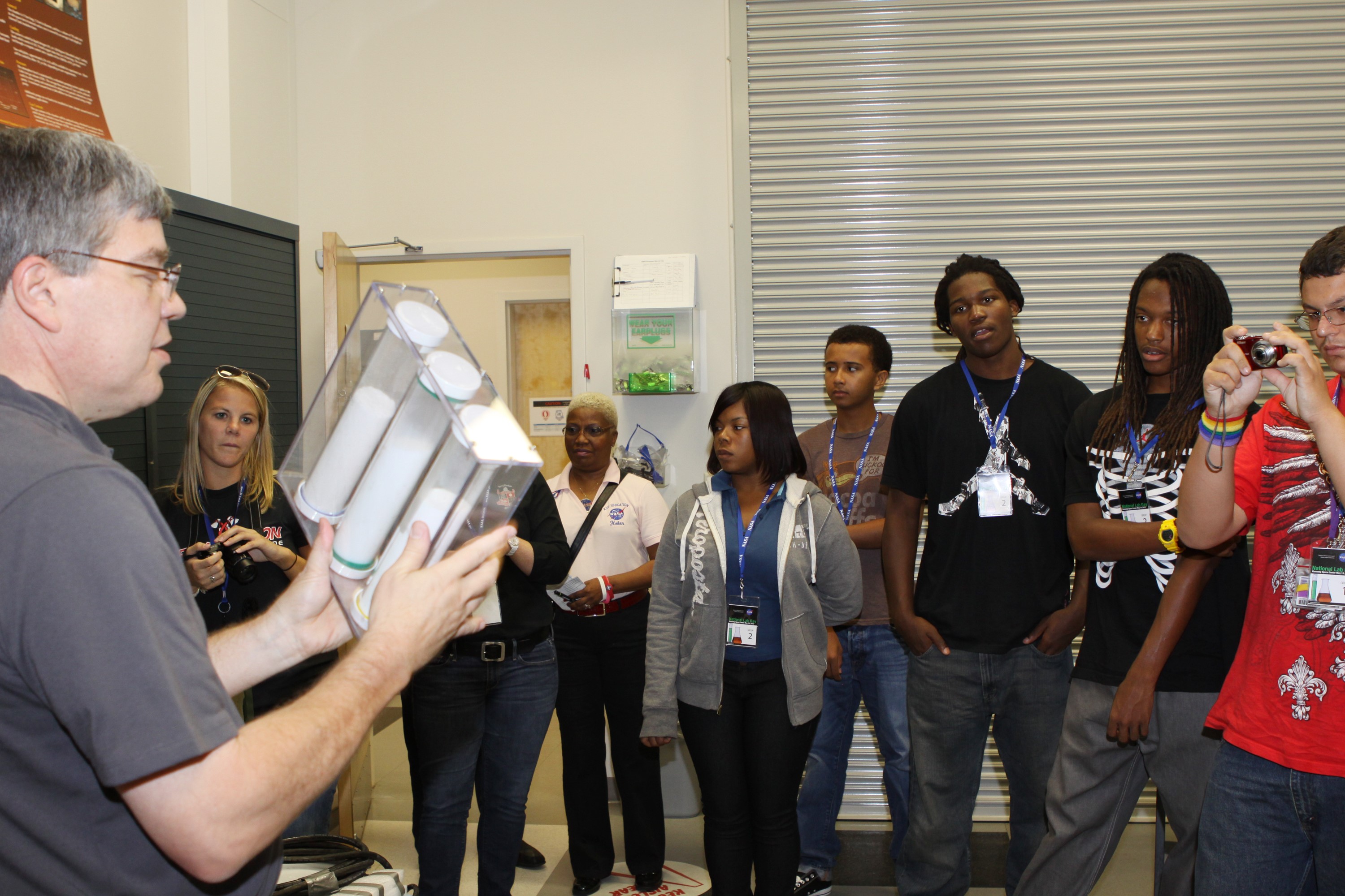 CAPE CANAVERAL, Fla. – Dr. Phil Metzger demonstrates an experiment to study the physics of granular materials to students in the Granular Physics and Regolith Operations Lab at the Space Life Sciences Lab facility.                 The 26 honor students in chemistry and biology and their teachers got a chance to visit a number of high-tech labs at Kennedy Space Center as part of an effort to encourage students in the areas of science, technology, engineering and math. The tenth and eleventh grade students from Terry Parker High School in Jacksonville, Fla., visited a number of vastly different labs during their one-day tour. The group's visit to Kennedy was hosted by the Education Office as part of a nationwide effort by the National Lab Network to help introduce the nation's students to science careers. Photo credit: NASA/Jim Grossmann