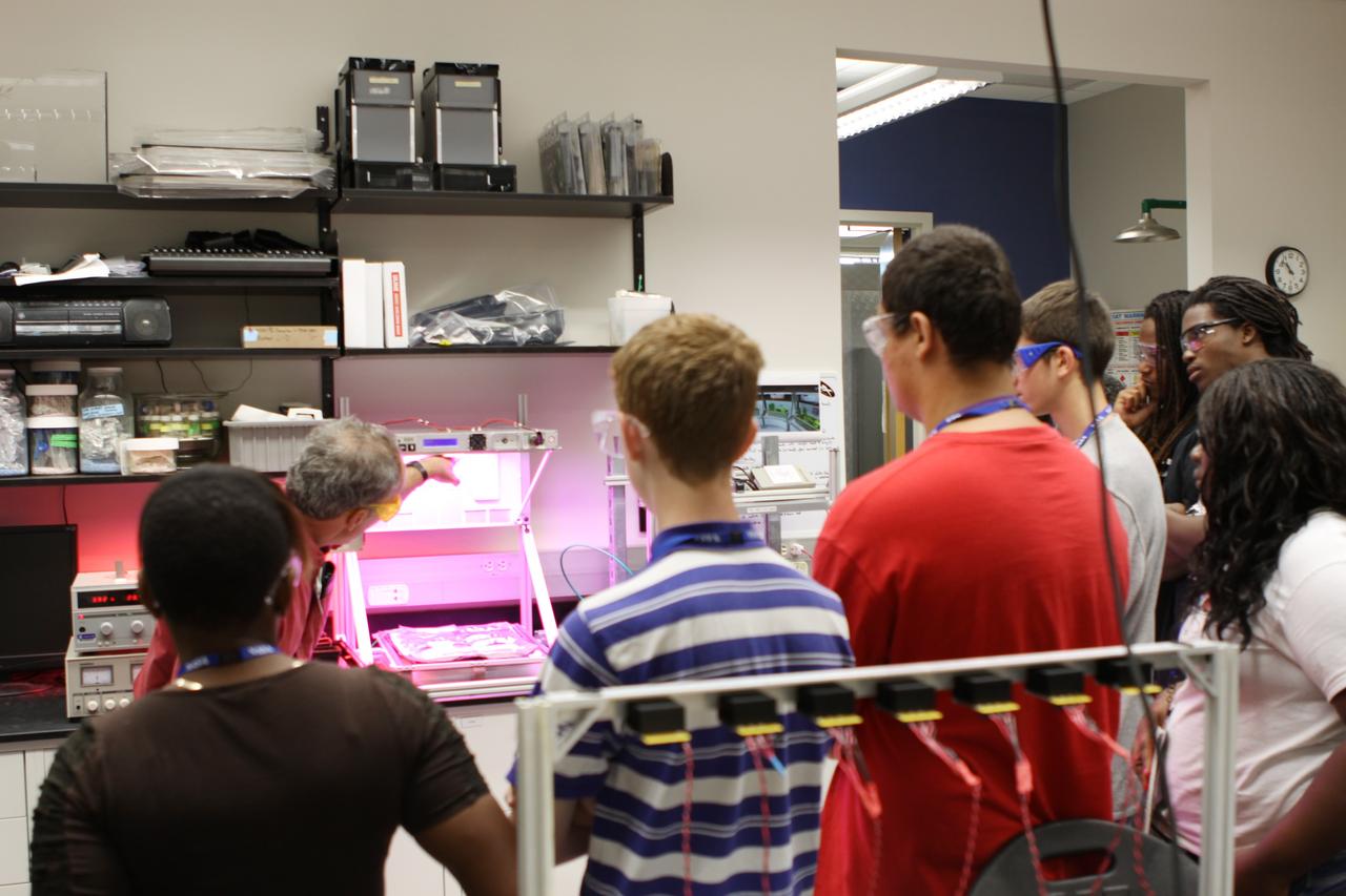 CAPE CANAVERAL, Fla. – Dr. Ray Wheeler explains a system for growing salad crops in space to students in the Life Support and Habitation Systems Lab at the Space Life Sciences Lab facility.          The 26 honor students in chemistry and biology and their teachers got a chance to visit a number of high-tech labs at Kennedy Space Center as part of an effort to encourage students in the areas of science, technology, engineering and math. The tenth and eleventh grade students from Terry Parker High School in Jacksonville, Fla., visited a number of vastly different labs during their one-day tour. The group's visit to Kennedy was hosted by the Education Office as part of a nationwide effort by the National Lab Network to help introduce the nation's students to science careers. Photo credit: NASA/Jim Grossmann