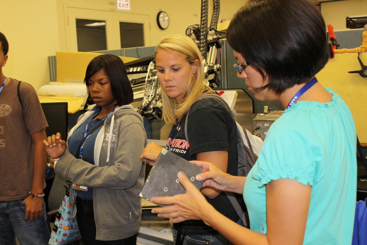 CAPE CANAVERAL, Fla. – Students and their teachers get some hands-on experience inside the applied physics lab in the Operations and Checkout Building.          The 26 honor students in chemistry and biology and their teachers got a chance to visit a number of high-tech labs at Kennedy Space Center as part of an effort to encourage students in the areas of science, technology, engineering and math. The tenth and eleventh grade students from Terry Parker High School in Jacksonville, Fla., visited a number of vastly different labs during their one-day tour. The group's visit to Kennedy was hosted by the Education Office as part of a nationwide effort by the National Lab Network to help introduce the nation's students to science careers. Photo credit: NASA/Jim Grossmann