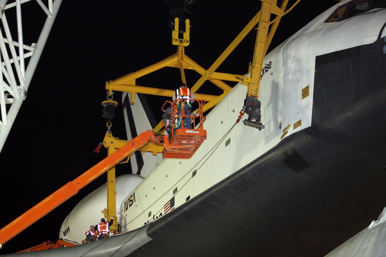 NEW YORK – Technicians attach the metal sling to the side of space shuttle Enterprise so it can be removed from the top of NASA's shuttle carrier aircraft. The work took place at John F. Kennedy International Airport in New York City. Enterprise, a prototype built to test aspects of the space shuttle design, will be displayed at the Intrepid Sea, Air and Space Museum in New York. Photo credit: NASA/Kim Shiflett