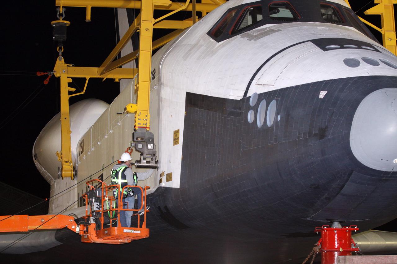 NEW YORK – A technician detaches a metal sling from space shuttle Enterprise as the shuttle was lowered onto a truck for transport to a protective hangar at John F. Kennedy International Airport in New York City. Enterprise, a prototype built to test aspects of the space shuttle design, will be displayed at the Intrepid Sea, Air and Space Museum in New York. Photo credit: NASA/Kim Shiflett