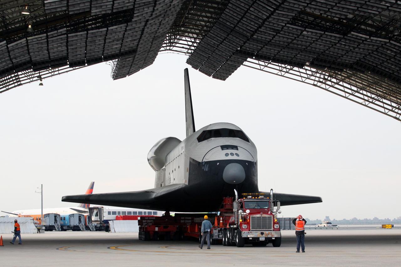 NEW YORK – Space shuttle Enterprise is backed into a protective hangar at John F. Kennedy International Airport in New York City. Enterprise, a prototype built to test aspects of the space shuttle design, will be displayed at the Intrepid Sea, Air and Space Museum in New York. Photo credit: NASA/Kim Shiflett
