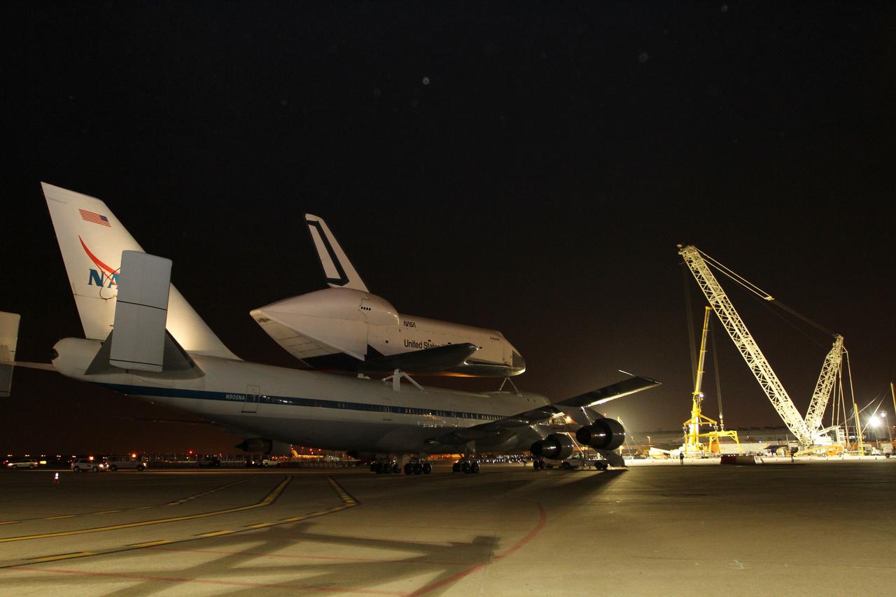 NEW YORK – Cranes and other equipment wait as NASA's shuttle carrier aircraft and space shuttle Enterprise are moved into place so the shuttle can be taken off the top of the aircraft. The work took place at John F. Kennedy International Airport in New York City. Enterprise, a prototype built to test aspects of the space shuttle design, will be displayed at the Intrepid Sea, Air and Space Museum in New York. Photo credit: NASA/Kim Shiflett