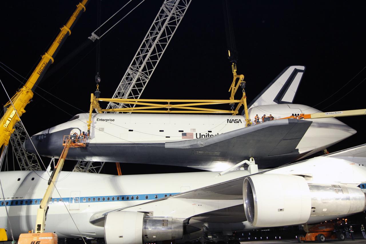 NEW YORK – Technicians attach the metal sling to the side of space shuttle Enterprise so it can be removed from the top of NASA's shuttle carrier aircraft. The work took place at John F. Kennedy International Airport in New York City. Enterprise, a prototype built to test aspects of the space shuttle design, will be displayed at the Intrepid Sea, Air and Space Museum in New York. Photo credit: NASA/Kim Shiflett
