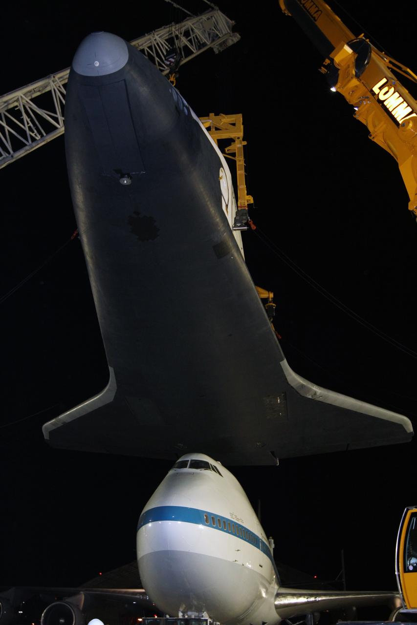 NEW YORK – Cranes carefully detach space shuttle Enterprise from the top of NASA's shuttle carrier aircraft. The work took place at John F. Kennedy International Airport in New York City. Enterprise, a prototype built to test aspects of the space shuttle design, will be displayed at the Intrepid Sea, Air and Space Museum in New York. Photo credit: NASA/Kim Shiflett