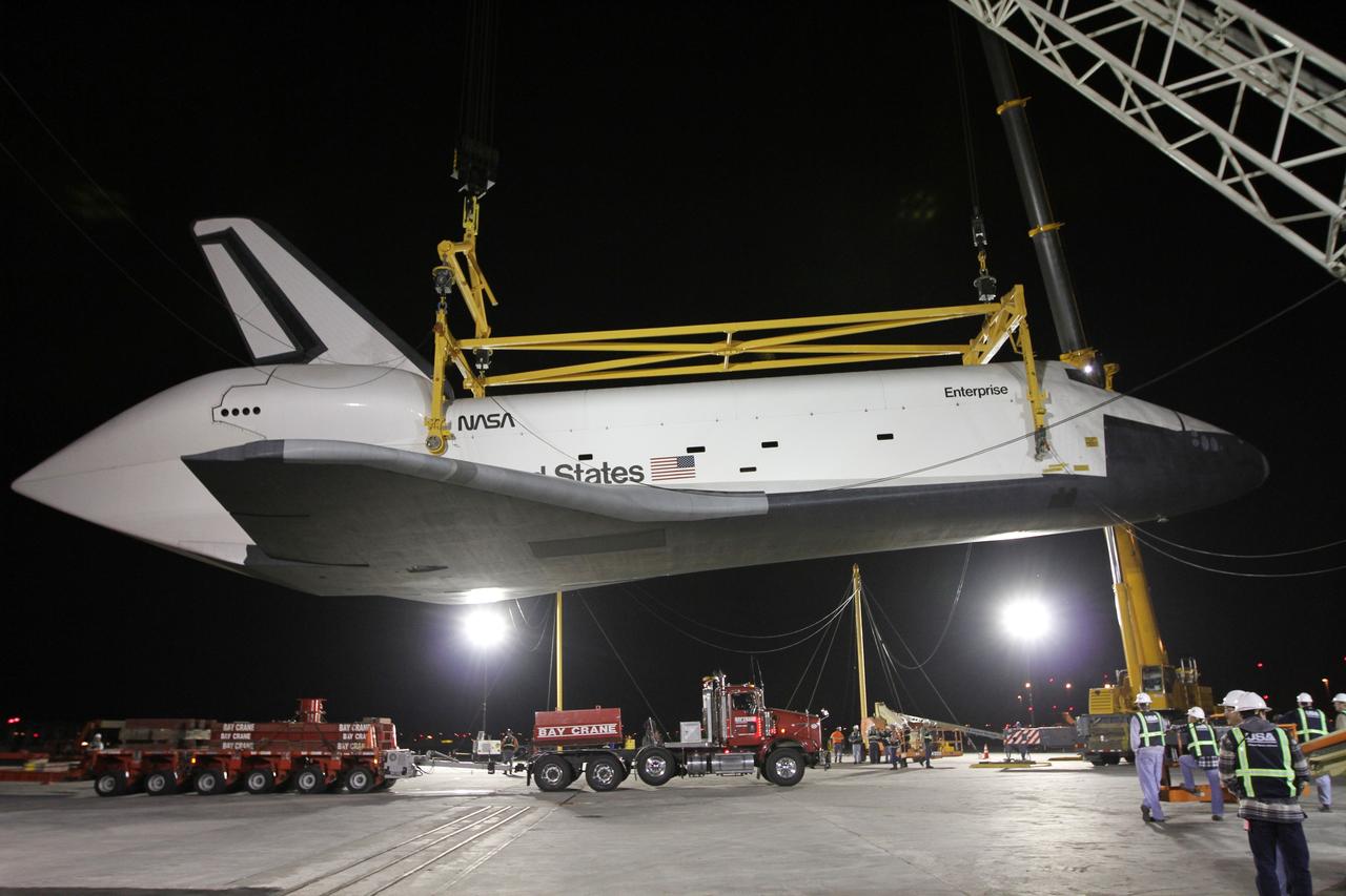 NEW YORK – A specialized truck bed is moved into place beneath space shuttle Enterprise so the prototype spacecraft can be moved into a hangar. The work took place at John F. Kennedy International Airport in New York City. Enterprise, a prototype built to test aspects of the space shuttle design, will be displayed at the Intrepid Sea, Air and Space Museum in New York. Photo credit: NASA/Kim Shiflett
