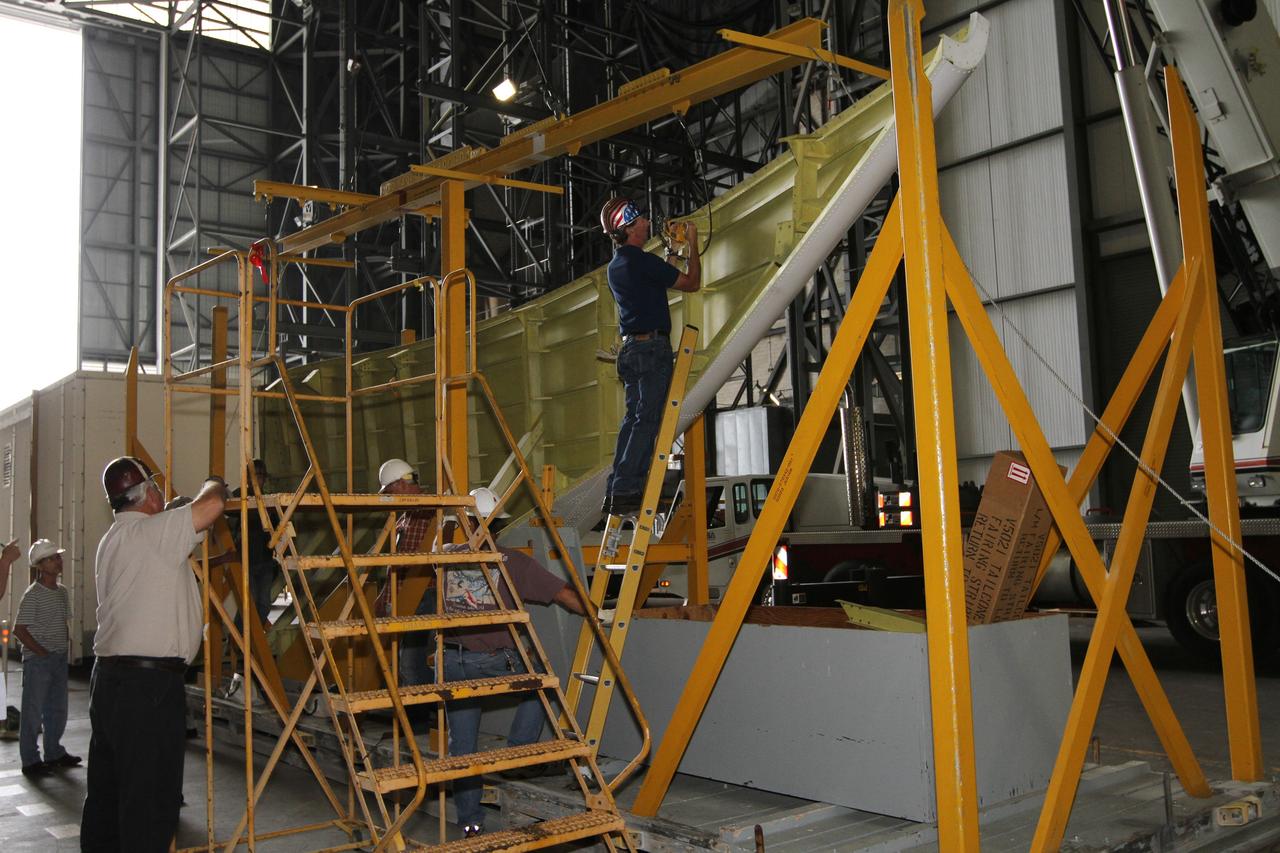 CAPE CANAVERAL, Fla. – Inside the Vehicle Assembly Building at NASA’s Kennedy Space Center in Florida, United Space Alliance technicians prepare the right side tail cone for buildup on space shuttle Endeavour. The tail cone protects space shuttle main engines during ferry flights on top of the Shuttle Carrier Aircraft, or SCA. The work is part of Transition and Retirement of the remaining space shuttles, Endeavour and Atlantis. Endeavour is being prepared for public display at the California Science Center in Los Angeles. Its ferry flight to California is targeted for mid-September. Endeavour was the last space shuttle added to NASA’s orbiter fleet. Over the course of its 19-year career, Endeavour spent 299 days in space during 25 missions. For more information, visit http://www.nasa.gov/shuttle. Photo credit: NASA/Kim Shiflett