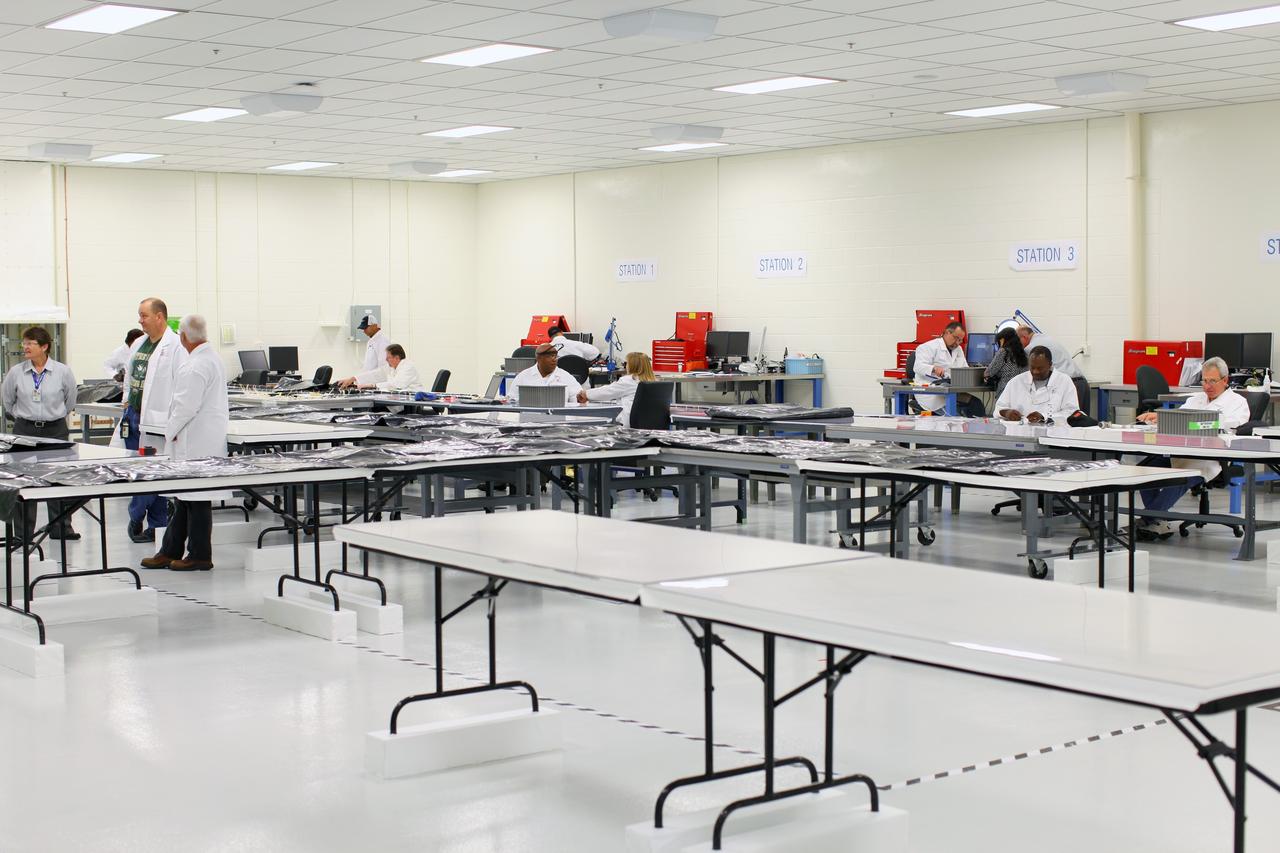 CAPE CANAVERAL, Fla. – Inside the Operations and Checkout Building high bay at NASA’s Kennedy Space Center in Florida, United Space Alliance workers are manufacturing harnesses which will be used on NASA’s Orion multi-purpose crew vehicle, or MPCV. During a tour of the facility, media representatives viewed Orion, several processing stations, and the Orion Test and Launch Control Center. The ground test vehicle will remain at Kennedy for acoustic and modal testing. The heat shield on the bottom of the module will be removed and replaced with a more flight-like heat shield that was built by Lockheed Martin in Denver and will be shipped to Kennedy for installation. The test vehicle will then be in its vehicle configuration for the splashdown test at Langley as NASA prepares for Exploration Flight Test-1. Photo credit: NASA/Frankie Martin