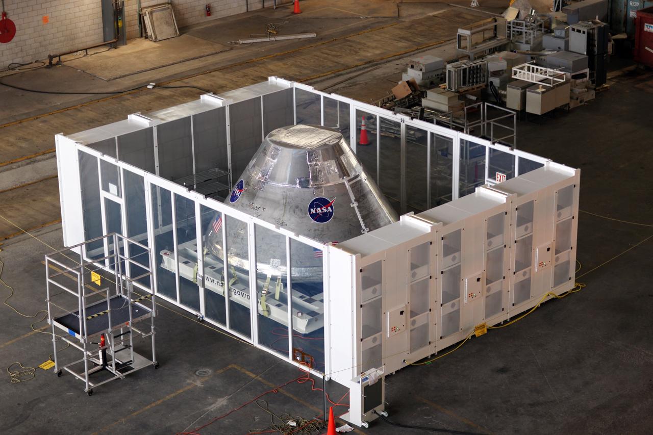 CAPE CANAVERAL, Fla. - An Orion test capsule sits inside a temporary clean room in High Bay 3 of the Vehicle Assembly Building at NASA's Kennedy Space Center in Florida during testing. The clean room, built by Astrotech, uses air flow produced by two banks of fans to keep particles from settling on the surface of a spacecraft during processing. Engineers are considering using the design in the future to protect the spacecraft after it is secured to the top of the Space Launch System rocket. Photo credit: NASA/Dmitri Gerondidakis