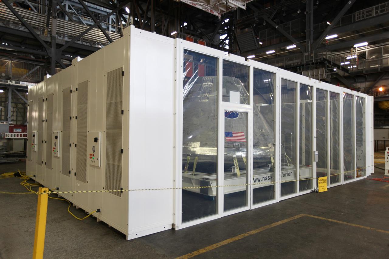 CAPE CANAVERAL, Fla. - An Orion test capsule sits inside a temporary clean room in High Bay 3 of the Vehicle Assembly Building at NASA's Kennedy Space Center in Florida during testing. The clean room, built by Astrotech, uses air flow produced by two banks of fans to keep particles from settling on the surface of a spacecraft during processing. Engineers are considering using the design in the future to protect the spacecraft after it is secured to the top of the Space Launch System rocket. Photo credit: NASA/Dmitri Gerondidakis