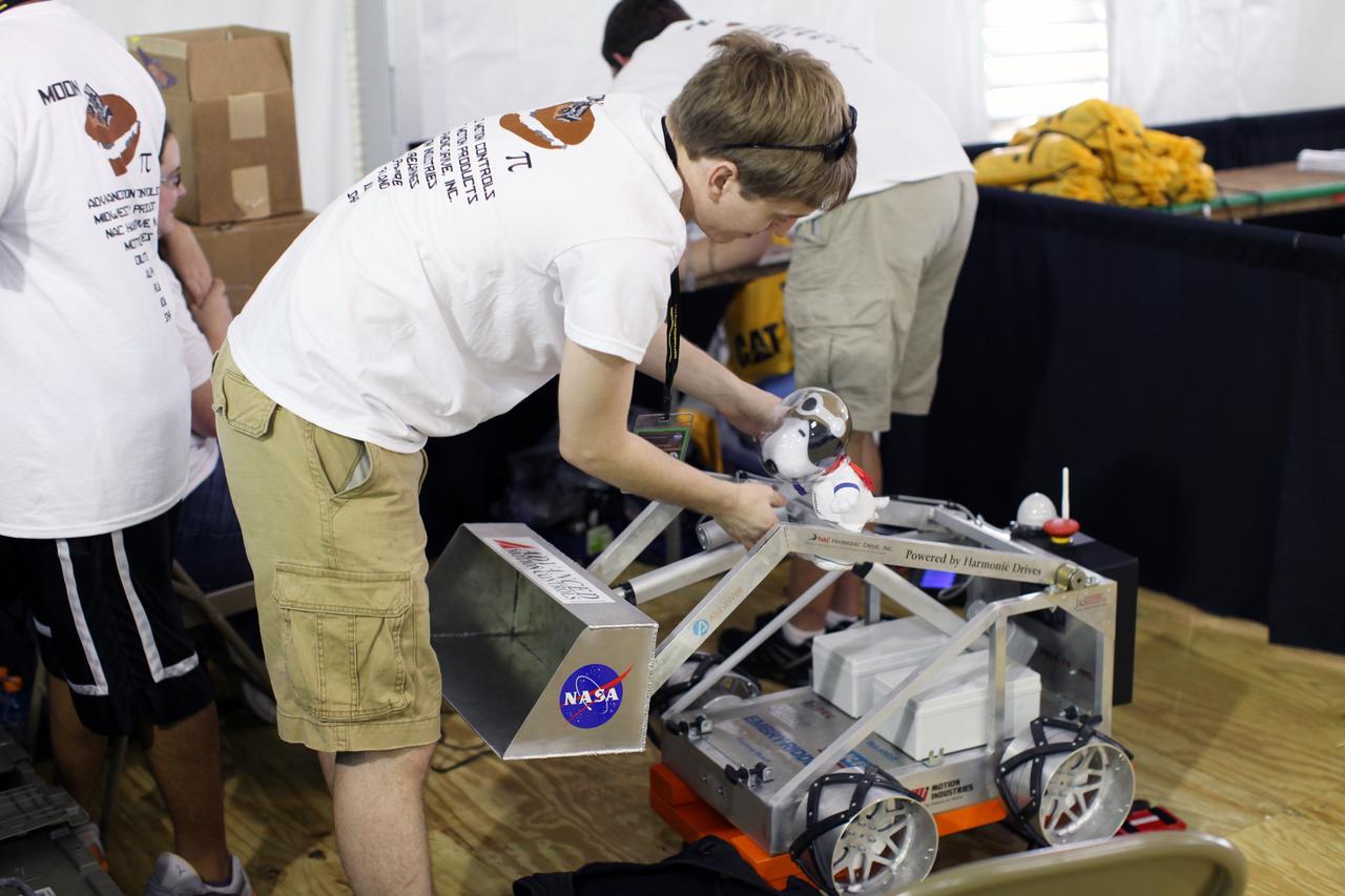 CAPE CANAVERAL, Fla. – “Snoopy” catches a ride aboard the lunabot built by the students from Embry-Riddle Aeronautical University, in Daytona Beach, Fla., during a practice session for the third annual Lunabotics Mining Competition at NASA’s Kennedy Space Center Visitor Complex in Florida.    More than 50 teams of undergraduate and graduate students from eight countries are participating. The teams have designed and built remote-controlled or autonomous robots that can excavate simulated lunar soil. During the competition, the teams' designs, known as lunabots, will go head-to-head to determine whose machine can collect and deposit the most simulated moon dust within a specified amount of time. The competition is a NASA Human Exploration and Operations Mission Directorate project designed to engage and retain students in the science, technology, engineering and mathematics, or STEM, fields of study. The project provides a competitive environment that may result in innovative ideas and solutions that potentially could be applied to future NASA missions. For more information, visit http://www.nasa.gov/lunabotics.  Photo credit: NASA/Frankie Martin