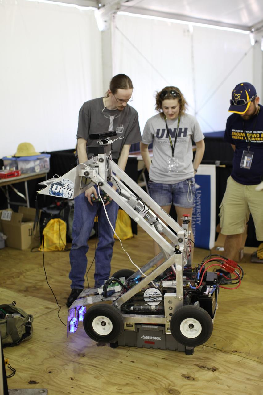 CAPE CANAVERAL, Fla. – Students from the University of New Hampshire, in Durham, N.H., put their lunabot through its paces during a practice session for the third annual Lunabotics Mining Competition at NASA’s Kennedy Space Center Visitor Complex in Florida.     More than 50 teams of undergraduate and graduate students from eight countries are participating. The teams have designed and built remote-controlled or autonomous robots that can excavate simulated lunar soil. During the competition, the teams' designs, known as lunabots, will go head-to-head to determine whose machine can collect and deposit the most simulated moon dust within a specified amount of time. The competition is a NASA Human Exploration and Operations Mission Directorate project designed to engage and retain students in the science, technology, engineering and mathematics, or STEM, fields of study. The project provides a competitive environment that may result in innovative ideas and solutions that potentially could be applied to future NASA missions. For more information, visit http://www.nasa.gov/lunabotics.  Photo credit: NASA/Frankie Martin