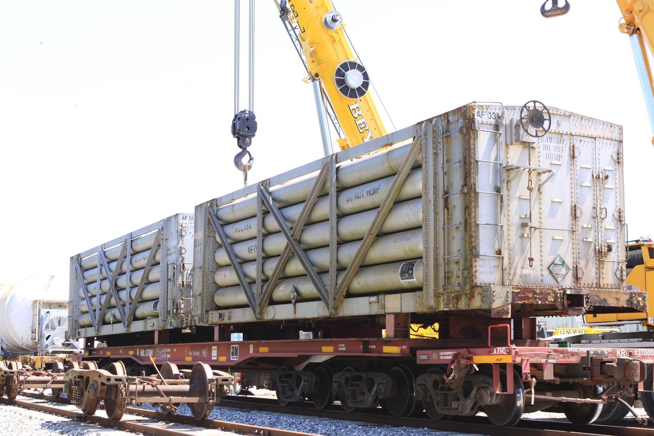 CAPE CANAVERAL, Fla. – At the NASA Railroad yard at Kennedy Space Center in Florida, cranes are enlisted to lift helium tank cars from their trucks onto flat cars in preparation for a journey to the Florida East Coast Railway interchange in Titusville, Fla., where the train’s tank cars will be transferred for delivery to the SpaceX engine test complex outside McGregor, Texas.  The yard is located in Kennedy’s Launch Complex 39 near the 525-foot-tall Vehicle Assembly Building, in the background.    The railroad cars were needed in support of the Space Shuttle Program but currently are not in use by NASA following the completion of the program in 2011. Originally, the tankers belonged to the U.S. Bureau of Mines.  At the peak of the shuttle program, there were approximately 30 cars in the fleet.  About half the cars were returned to the bureau as launch activity diminished. Five tank cars are being loaned to SpaceX and repurposed to support their engine tests in Texas. Eight cars previously were shipped to California on loan to support the SpaceX Falcon 9 rocket launches from Space Launch Complex-4 on Vandenberg Air Force Base.  SpaceX already has three helium tank cars previously used for the shuttle program at Space Launch Complex-40 on Cape Canaveral Air Force Station in Florida. For more information, visit http://www.nasa.gov/spacex.  Photo credit: NASA/Jim Grossmann
