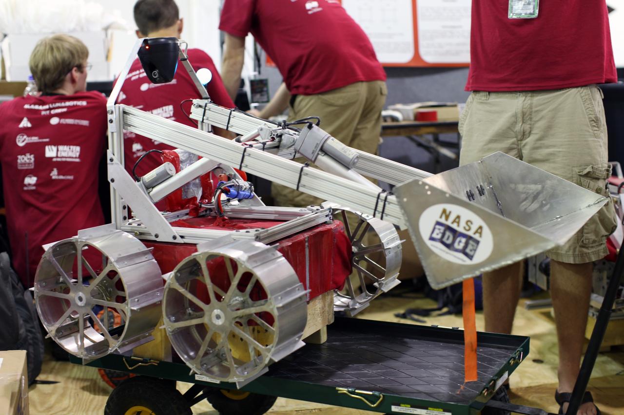 CAPE CANAVERAL, Fla. – At NASA’s Kennedy Space Center Visitor Complex in Florida, college students prepare their custom lunabot for NASA’s Lunabotics Mining Competition.    The mining competition is sponsored by NASA Kennedy Space Center’s Education Office for the agency’s Exploration Systems Mission Directorate. Undergraduate and graduate students from more than 50 universities and colleges in the U.S. and other countries use their remote-controlled Lunabots to maneuver and dig in a supersized sandbox filled with a crushed material that has characteristics similar to lunar soil. Photo credit: NASA/Frankie Martin