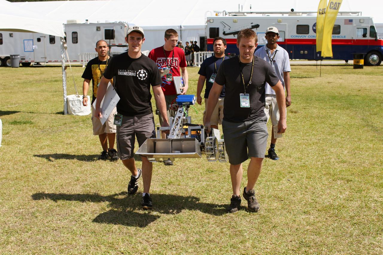 CAPE CANAVERAL, Fla. - At NASA’s Kennedy Space Center Visitor Complex in Florida, college students from California State University in Chico, prepare their custom lunabot, BEAR, for NASA’s Lunabotics Mining Competition.    The mining competition is sponsored by NASA Kennedy Space Center’s Education Office for the agency’s Exploration Systems Mission Directorate. Undergraduate and graduate students from more than 50 universities and colleges in the U.S. and other countries use their remote-controlled Lunabots to maneuver and dig in a supersized sandbox filled with a crushed material that has characteristics similar to lunar soil. For more information, visit www.nasa.gov/lunabotics. Photo credit: NASA/Frankie Martin