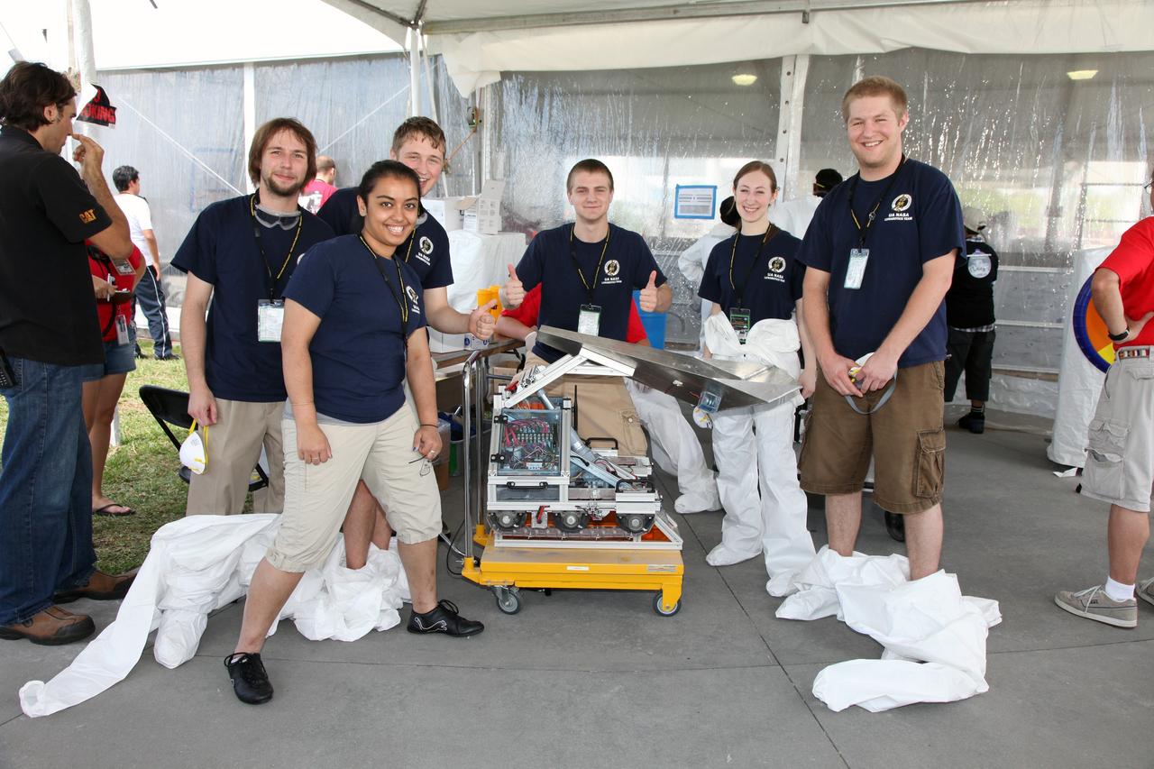 CAPE CANAVERAL, Fla. – At NASA’s Kennedy Space Center Visitor Complex in Florida, college students from The University of Akron in Ohio prepare their Lunabot, S.T.E.V.E., for the Lunarena during NASA’s Lunabotics Mining Competition.    The mining competition is sponsored by NASA Kennedy Space Center’s Education Office for the agency’s Exploration Systems Mission Directorate. Undergraduate and graduate students from more than 50 universities and colleges in the U.S. and other countries use their remote-controlled Lunabots to maneuver and dig in a supersized sandbox filled with a crushed material that has characteristics similar to lunar soil. For more information, visit www.nasa.gov/lunabotics. Photo credit: NASA/Frankie Martin