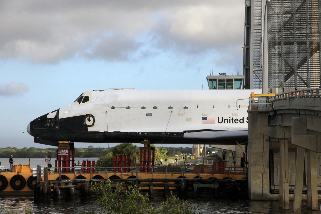 CAPE CANAVERAL, Fla. – The barge transporting the high-fidelity space shuttle model travels through the shallow waters of the locks at Port Canaveral, Fla., during the first leg of their journey from NASA’s Kennedy Space Center in Florida to Johnson Space Center's visitor center in Houston.     The model was built in Apopka, Fla., by Guard-Lee and installed at Kennedy Space Center Visitor Complex in 1993.The model has been parked at the turn basin the past five months to allow the Kennedy Space Center Visitor Complex to begin building a new facility to display space shuttle Atlantis in 2013. For more information about Johnson’s visitor center, called Space Center Houston, visit http://www.spacecenter.org. Photo credit: NASA/Jim Grossmann