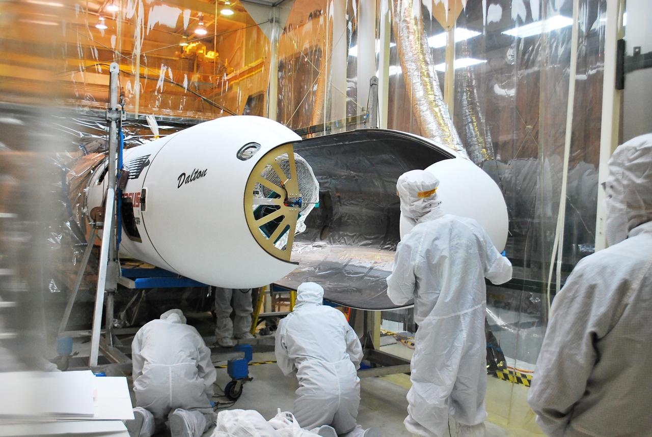 VANDENBERG AFB, Calif. – Technicians install the second half of the payload fairing over the NuSTAR spacecraft as they continue to process the spacecraft and its Pegasus rocket for launch. NuSTAR stands for Nuclear Spectroscopic Telescope Array. Photo credit: NASA/Randy Beaudoin