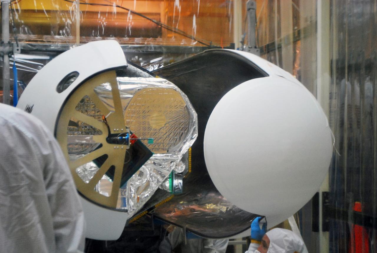 VANDENBERG AFB, Calif. – Technicians install the second half of the payload fairing over the NuSTAR spacecraft as they continue to process the spacecraft and its Pegasus rocket for launch. NuSTAR stands for Nuclear Spectroscopic Telescope Array. Photo credit: NASA/Randy Beaudoin