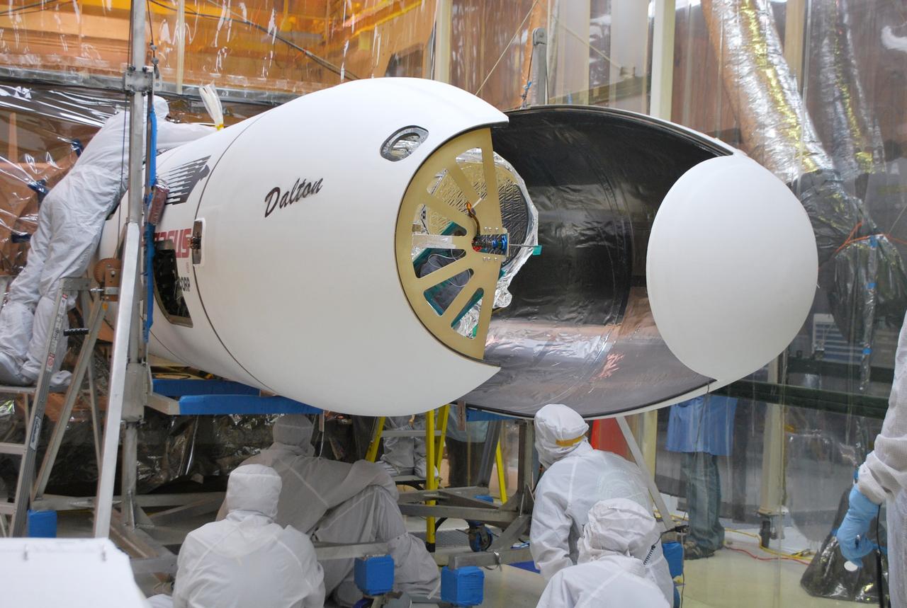 VANDENBERG AFB, Calif. – Technicians install the second half of the payload fairing over the NuSTAR spacecraft as they continue to process the spacecraft and its Pegasus rocket for launch. NuSTAR stands for Nuclear Spectroscopic Telescope Array. Photo credit: NASA/Randy Beaudoin