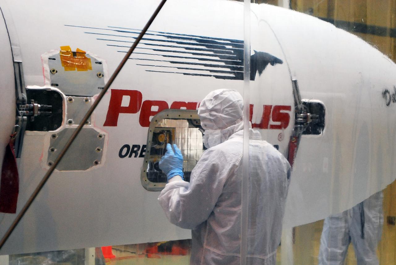VANDENBERG AFB, Calif. – A technicians checks the installation of the payload fairing over the NuSTAR spacecraft as processing continues for the spacecraft and its Pegasus rocket for launch. NuSTAR stands for Nuclear Spectroscopic Telescope Array. Photo credit: NASA/Randy Beaudoin