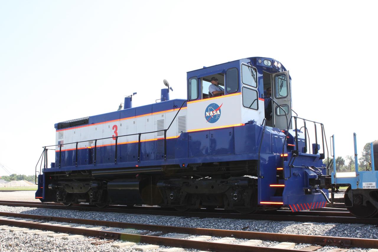 CAPE CANAVERAL, Fla. – NASA Railroad locomotive No. 3 is enlisted to deliver tank cars from NASA’s Kennedy Space Center in Florida to the Florida East Coast Railway interchange in Titusville, Fla.  The locomotive is one of three NASA Railroad locomotives built for the Toledo, Peoria and Western, or TP&W, between 1968 and 1970.  It is a GM Electromotive Division SW-1500 switcher.  The locomotive was acquired by NASA from the TP&W in 1984 and painted in the NASA Railroad paint scheme.  The power plant was completely overhauled in 2009.  The locomotive will pull the train to the interchange in Titusville, where the train’s helium tank cars, a liquid oxygen tank car, and a liquid hydrogen dewar or tank car will be transferred for delivery to the SpaceX engine test complex outside McGregor, Texas.      The railroad cars were needed in support of the Space Shuttle Program but currently are not in use by NASA following the completion of the program in 2011. Originally, the tankers belonged to the U.S. Bureau of Mines.  At the peak of the shuttle program, there were approximately 30 cars in the fleet.  About half the cars were returned to the bureau as launch activity diminished. Five tank cars are being loaned to SpaceX and repurposed to support their engine tests in Texas. Eight cars previously were shipped to California on loan to support the SpaceX Falcon 9 rocket launches from Space Launch Complex-4 on Vandenberg Air Force Base.  SpaceX already has three helium tank cars previously used for the shuttle program at Space Launch Complex-40 on Cape Canaveral Air Force Station in Florida. For more information, visit http://www.nasa.gov/spacex.  Photo credit: NASA/Jim Grossmann