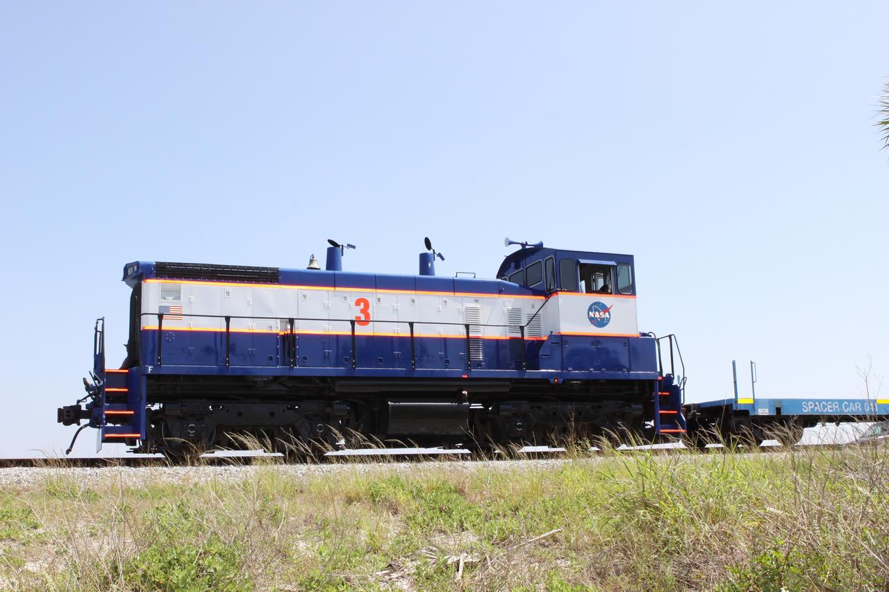 CAPE CANAVERAL, Fla. – NASA Railroad locomotive No. 3 delivers tank cars from NASA’s Kennedy Space Center in Florida to the Florida East Coast Railway interchange in Titusville, Fla.  The locomotive is one of three NASA Railroad locomotives built for the Toledo, Peoria and Western, or TP&W, between 1968 and 1970.  It is a GM Electromotive Division SW-1500 switcher.  The locomotive was acquired by NASA from the TP&W in 1984 and painted in the NASA Railroad paint scheme.  The power plant was completely overhauled in 2009.  The locomotive will pull the train to the interchange in Titusville, where the train’s helium tank cars, a liquid oxygen tank car, and a liquid hydrogen dewar or tank car will be transferred for delivery to the SpaceX engine test complex outside McGregor, Texas.    The railroad cars were needed in support of the Space Shuttle Program but currently are not in use by NASA following the completion of the program in 2011. Originally, the tankers belonged to the U.S. Bureau of Mines.  At the peak of the shuttle program, there were approximately 30 cars in the fleet.  About half the cars were returned to the bureau as launch activity diminished. Five tank cars are being loaned to SpaceX and repurposed to support their engine tests in Texas. Eight cars previously were shipped to California on loan to support the SpaceX Falcon 9 rocket launches from Space Launch Complex-4 on Vandenberg Air Force Base.  SpaceX already has three helium tank cars previously used for the shuttle program at Space Launch Complex-40 on Cape Canaveral Air Force Station in Florida. For more information, visit http://www.nasa.gov/spacex.  Photo credit: NASA/Jim Grossmann