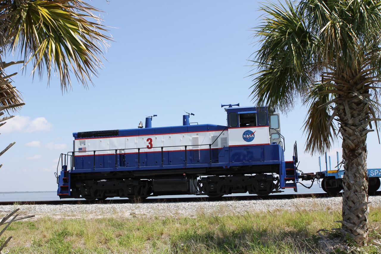 CAPE CANAVERAL, Fla. – NASA Railroad locomotive No. 3 delivers tank cars from NASA’s Kennedy Space Center in Florida to the Florida East Coast Railway interchange in Titusville, Fla.  The locomotive is one of three NASA Railroad locomotives built for the Toledo, Peoria and Western, or TP&W, between 1968 and 1970.  It is a GM Electromotive Division SW-1500 switcher.  The locomotive was acquired by NASA from the TP&W in 1984 and painted in the NASA Railroad paint scheme.  The power plant was completely overhauled in 2009.  The locomotive will pull the train to the interchange in Titusville, where the train’s helium tank cars, a liquid oxygen tank car, and a liquid hydrogen dewar or tank car will be transferred for delivery to the SpaceX engine test complex outside McGregor, Texas.    The railroad cars were needed in support of the Space Shuttle Program but currently are not in use by NASA following the completion of the program in 2011. Originally, the tankers belonged to the U.S. Bureau of Mines.  At the peak of the shuttle program, there were approximately 30 cars in the fleet.  About half the cars were returned to the bureau as launch activity diminished. Five tank cars are being loaned to SpaceX and repurposed to support their engine tests in Texas. Eight cars previously were shipped to California on loan to support the SpaceX Falcon 9 rocket launches from Space Launch Complex-4 on Vandenberg Air Force Base.  SpaceX already has three helium tank cars previously used for the shuttle program at Space Launch Complex-40 on Cape Canaveral Air Force Station in Florida. For more information, visit http://www.nasa.gov/spacex.  Photo credit: NASA/Jim Grossmann