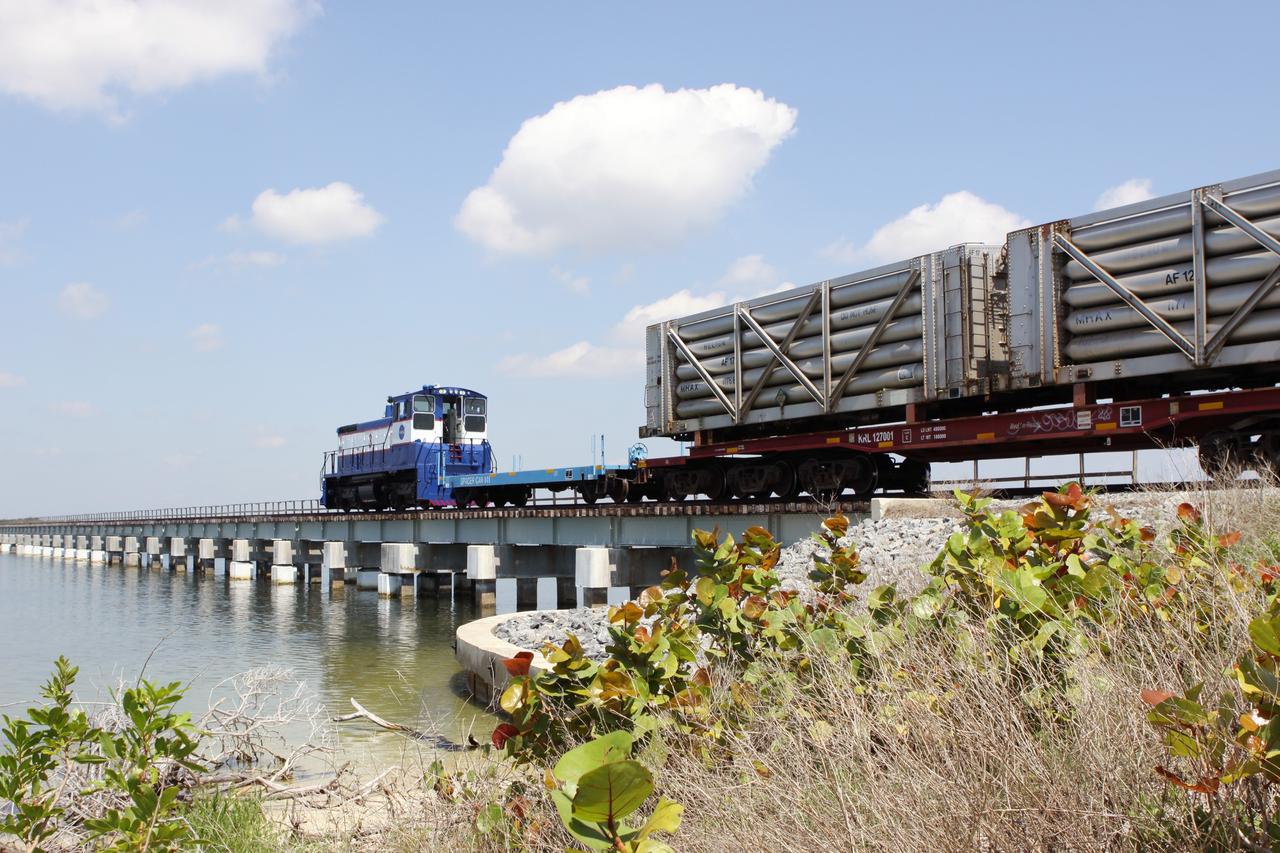 CAPE CANAVERAL, Fla. – A NASA Railroad train crosses the railroad’s Jay Jay Railroad Bridge north of Launch Complex 39 at NASA’s Kennedy Space Center in Florida. The train is on its way to the Florida East Coast Railway interchange in Titusville, Fla., where the train’s helium tank cars, a liquid oxygen tank car, and a liquid hydrogen dewar or tank car will be transferred for delivery to the SpaceX engine test complex outside McGregor, Texas.    The railroad cars were needed in support of the Space Shuttle Program but currently are not in use by NASA following the completion of the program in 2011. Originally, the tankers belonged to the U.S. Bureau of Mines.  At the peak of the shuttle program, there were approximately 30 cars in the fleet.  About half the cars were returned to the bureau as launch activity diminished. Five tank cars are being loaned to SpaceX and repurposed to support their engine tests in Texas. Eight cars previously were shipped to California on loan to support the SpaceX Falcon 9 rocket launches from Space Launch Complex-4 on Vandenberg Air Force Base.  SpaceX already has three helium tank cars previously used for the shuttle program at Space Launch Complex-40 on Cape Canaveral Air Force Station in Florida. For more information, visit http://www.nasa.gov/spacex.  Photo credit: NASA/Jim Grossmann