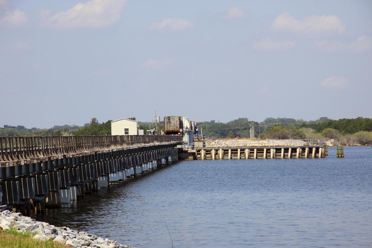 CAPE CANAVERAL, Fla. – A NASA Railroad train has crossed the Indian River on the railroad’s Jay Jay Railroad Bridge north of Launch Complex 39 at NASA’s Kennedy Space Center in Florida. The train is on its way to the Florida East Coast Railway interchange in Titusville, Fla., where the train’s helium tank cars, a liquid oxygen tank car, and a liquid hydrogen dewar or tank car will be transferred for delivery to the SpaceX engine test complex outside McGregor, Texas.    The railroad cars were needed in support of the Space Shuttle Program but currently are not in use by NASA following the completion of the program in 2011. Originally, the tankers belonged to the U.S. Bureau of Mines.  At the peak of the shuttle program, there were approximately 30 cars in the fleet.  About half the cars were returned to the bureau as launch activity diminished. Five tank cars are being loaned to SpaceX and repurposed to support their engine tests in Texas. Eight cars previously were shipped to California on loan to support the SpaceX Falcon 9 rocket launches from Space Launch Complex-4 on Vandenberg Air Force Base.  SpaceX already has three helium tank cars previously used for the shuttle program at Space Launch Complex-40 on Cape Canaveral Air Force Station in Florida. For more information, visit http://www.nasa.gov/spacex.  Photo credit: NASA/Jim Grossmann