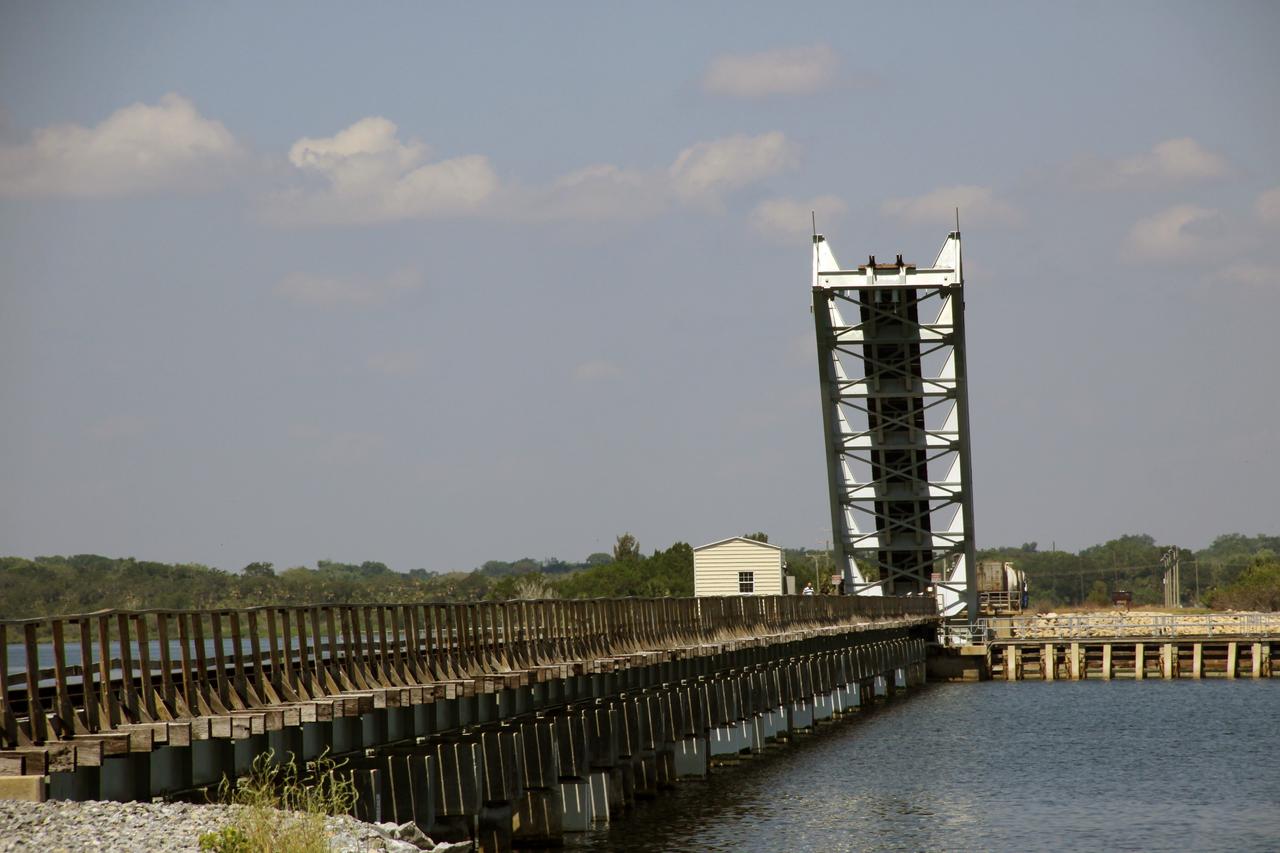 CAPE CANAVERAL, Fla. – The drawbridge span of the NASA Railroad’s Jay Jay Railroad Bridge over the Indian River north of Launch Complex 39 at NASA’s Kennedy Space Center in Florida is reopened following the passage of a NASA Railroad train.  The permanent configuration of the bridge is open the span is lowered only for a train to cross.    The railroad cars were needed in support of the Space Shuttle Program but currently are not in use by NASA following the completion of the program in 2011. Originally, the tankers belonged to the U.S. Bureau of Mines.  At the peak of the shuttle program, there were approximately 30 cars in the fleet.  About half the cars were returned to the bureau as launch activity diminished. Five tank cars are being loaned to SpaceX and repurposed to support their engine tests in Texas. Eight cars previously were shipped to California on loan to support the SpaceX Falcon 9 rocket launches from Space Launch Complex-4 on Vandenberg Air Force Base.  SpaceX already has three helium tank cars previously used for the shuttle program at Space Launch Complex-40 on Cape Canaveral Air Force Station in Florida. For more information, visit http://www.nasa.gov/spacex.  Photo credit: NASA/Jim Grossmann