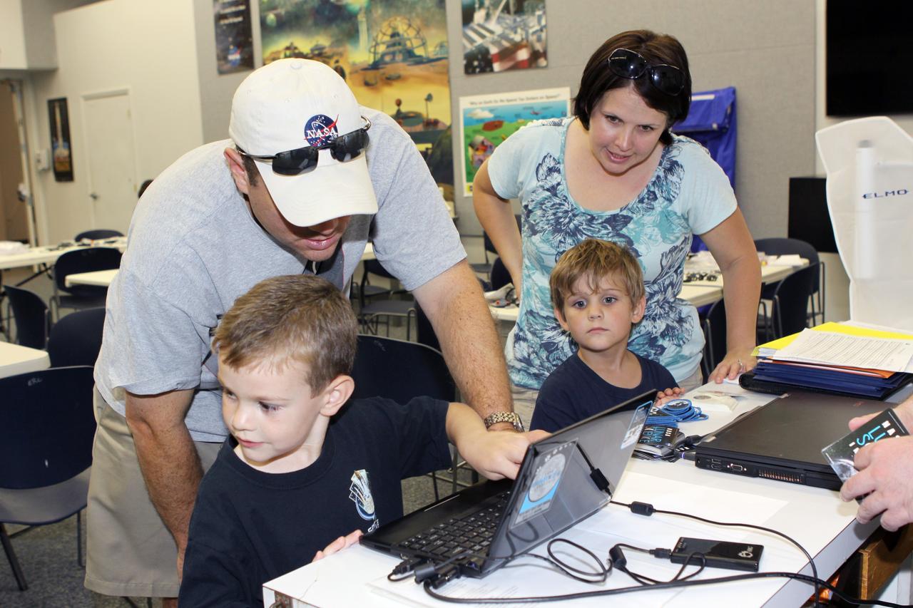 CAPE CANAVERAL, Fla. – Children work with family members in the KSC Family Exploration Station at the Kennedy Space Center Visitor Complex. The station offered numerous scientific- and engineering-related activities for children to experience. Photo credit: NASA/Jim Grossmann