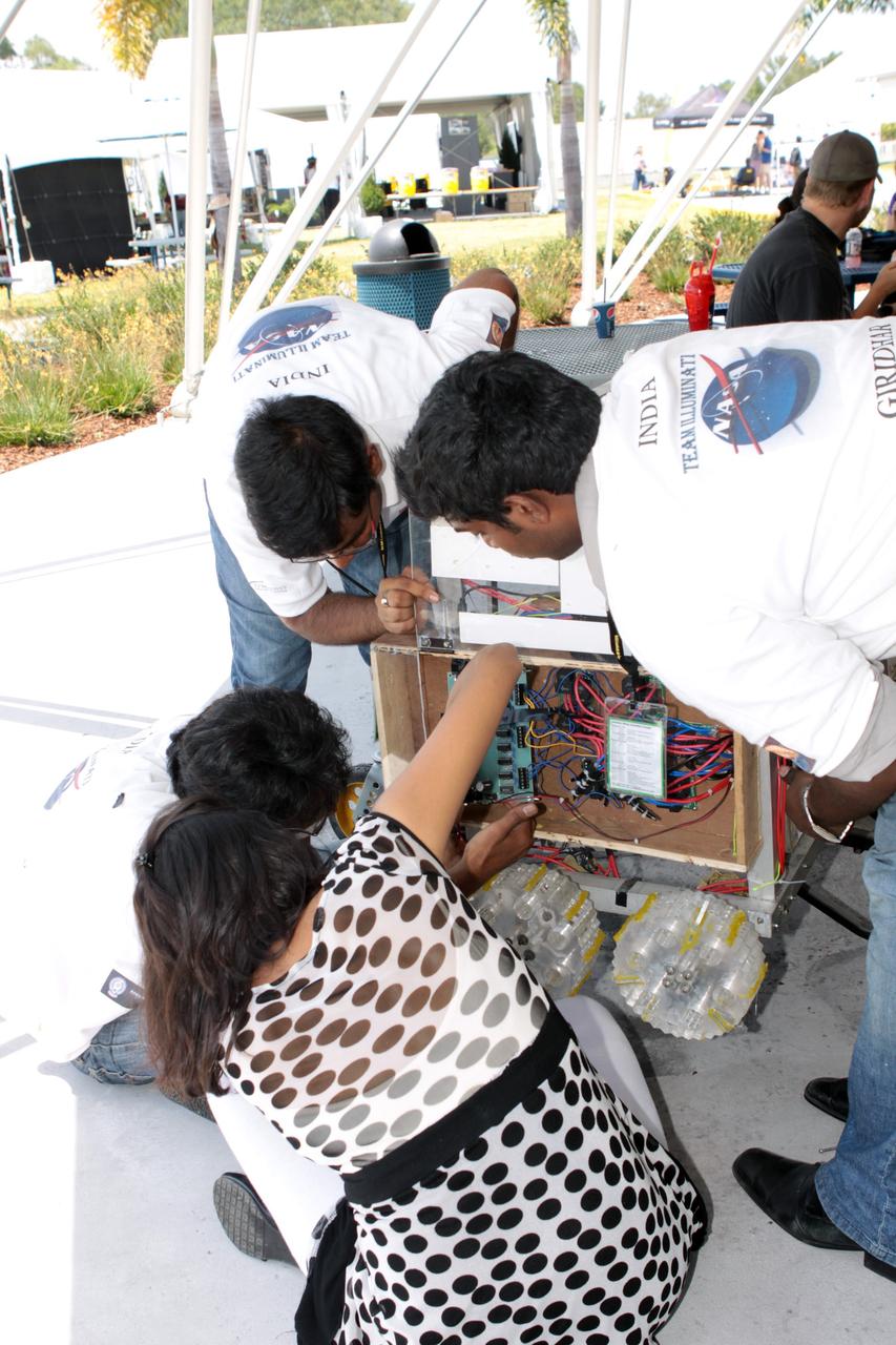 CAPE CANAVERAL, Fla. – A team of competitors readies its robotic vehicle taking part in the racing portion of NASA's Lunabotics Mining Competition at the Kennedy Space Center Visitor Complex in Florida. Although much of the competition was based on a vehicle's ability to dig soil, the festivities also included head-to-head runs for the robotic craft. Photo credit: NASA/Jim Grossmann