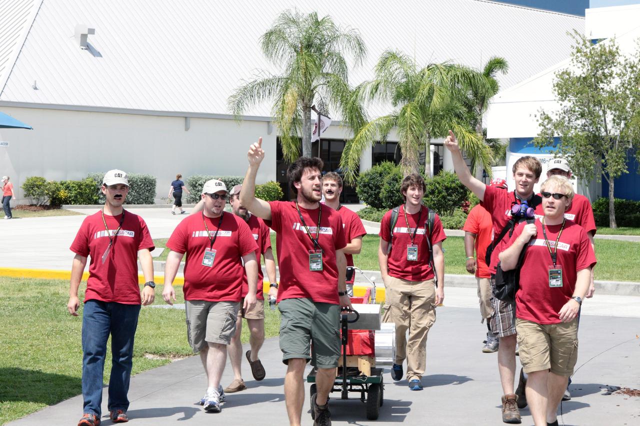 CAPE CANAVERAL, Fla. – A team of competitors parades its robotic vehicle before taking part in the racing portion of NASA's Lunabotics Mining Competition at the Kennedy Space Center Visitor Complex in Florida. Although much of the competition was based on a vehicle's ability to dig soil, the festivities also included head-to-head runs for the robotic craft. Photo credit: NASA/Jim Grossmann