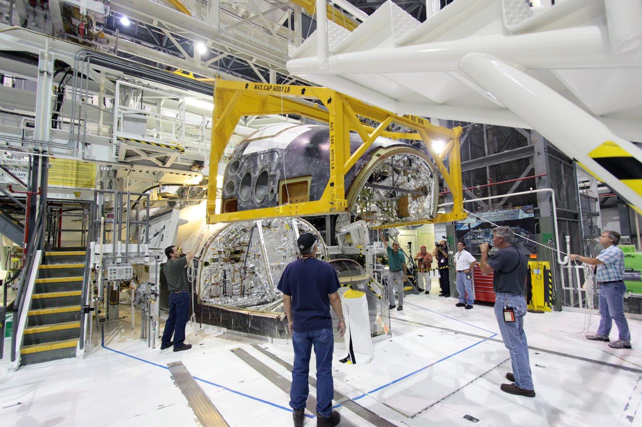 CAPE CANAVERAL, Fla. – In Orbiter Processing Facility-1 at NASA’s Kennedy Space Center in Florida, United Space Alliance technicians position the forward reaction control system over  space shuttle Atlantis during the system’s reinstallation on the shuttle.     The system helped the shuttle maneuver while it was in orbit. Atlantis’ FRCS was removed and sent to White Sands Test Facility in New Mexico to be cleaned of its toxic propellants. The work is part of the Space Shuttle Program’s transition and retirement processing of the shuttle fleet.  A groundbreaking was held Jan. 18 for Atlantis' future home, a 65,000-square-foot exhibit hall in Shuttle Plaza at the Kennedy Space Center Visitor Complex. Atlantis is scheduled to roll over to the visitor complex in November in preparation for the exhibit’s grand opening in July 2013. For more information, visit http://www.nasa.gov/shuttle.  Photo credit: NASA/Jim Grossmann