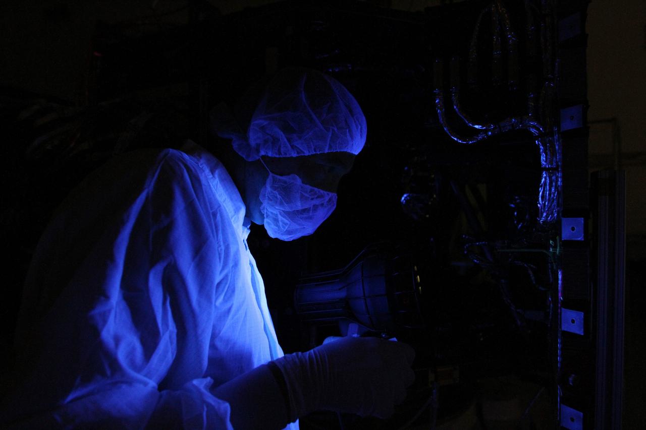 CAPE CANAVERAL, Fla. – A technician performs a black light inspection on one of NASA's Radiation Belt Storm Probes inside the clean room high bay at Astrotech payload processing facility. Black light inspection uses UVA fluorescence to detect possible microcontamination, small cracks or fluid leaks.     The Radiation Belt Storm Probes, or RBSP, mission will help us understand the sun’s influence on Earth and near-Earth space by studying the Earth’s radiation belts on various scales of space and time. RBSP will begin its mission of exploration of Earth's Van Allen radiation belts and the extremes of space weather after its launch aboard a United Launch Alliance Atlas V rocket. For more information, visit http://www.nasa.gov/rbsp. Photo credit: NASA/Kim Shiflett