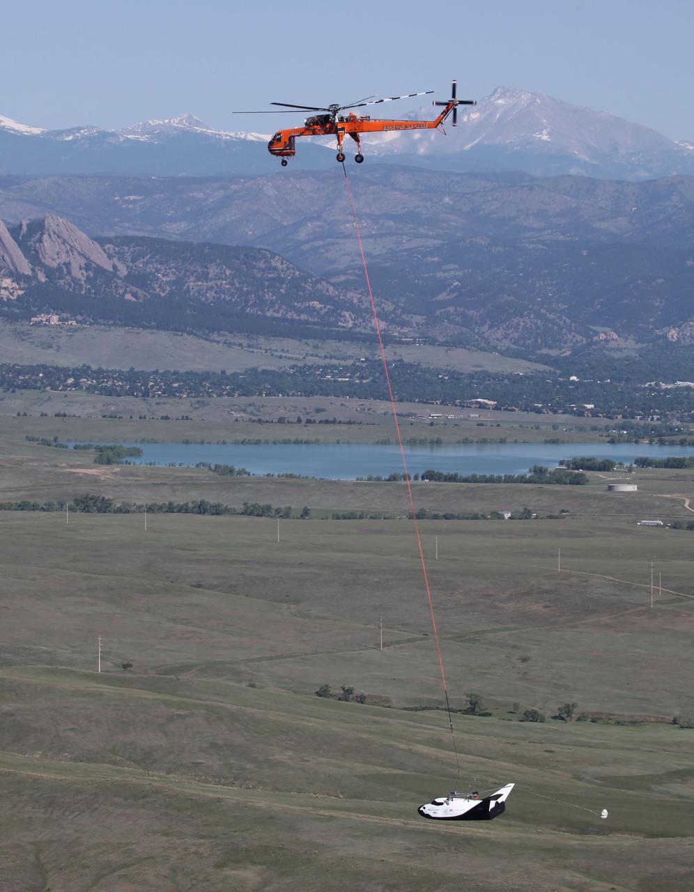 LOUISVILLE, Colo. – An Erickson Air-Crane helicopter lifts Sierra Nevada Corporation Space Systems’ Dream Chaser full-scale test vehicle to verify proper aerodynamic flight performance near the Rocky Mountain Metropolitan Airport in Jefferson County, Colo. This captive-carry test is one of several milestones the company is meeting during its partnership with NASA’s Commercial Crew Program CCP. Data from this test will provide SNC an early opportunity to evaluate and prove hardware, facilities and ground operations in preparation for approach and landing tests scheduled for later this year.     In 2011, NASA selected Sierra Nevada during Commercial Crew Development Round 2 CCDev2) activities to mature the design and development of a crew transportation system with the overall goal of accelerating a United States-led capability to the International Space Station. The goal of CCP is to drive down the cost of space travel as well as open up space to more people than ever before by balancing industry’s own innovative capabilities with NASA's 50 years of human spaceflight experience. Six other aerospace companies also are maturing launch vehicle and spacecraft designs under CCDev2, including Alliant Techsystems Inc. ATK, The Boeing Co., Excalibur Almaz Inc., Blue Origin, Space Exploration Technologies SpaceX, and United Launch Alliance ULA. For more information, visit www.nasa.gov/commercialcrew. Image credit: Sierra Nevada Corp.
