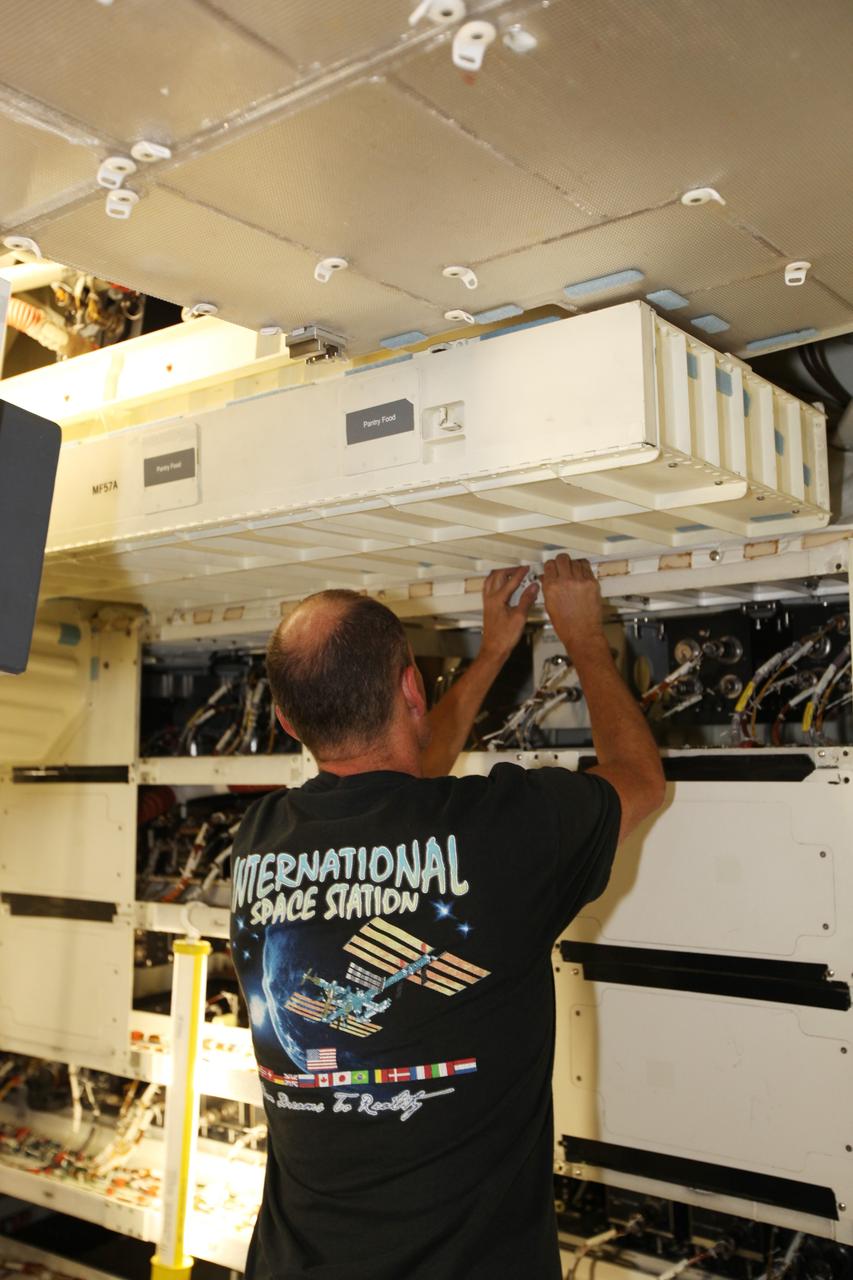 A technician installs a set of lockers on the middeck of space shuttle Atlantis as the spacecraft is prepared for public display. The work is taking place as Atlantis sits inside Orbiter Processing Facility-1 at NASA's Kennedy Space Center in Florida. Photo credit: NASA/Dmitri Gerondidakis
